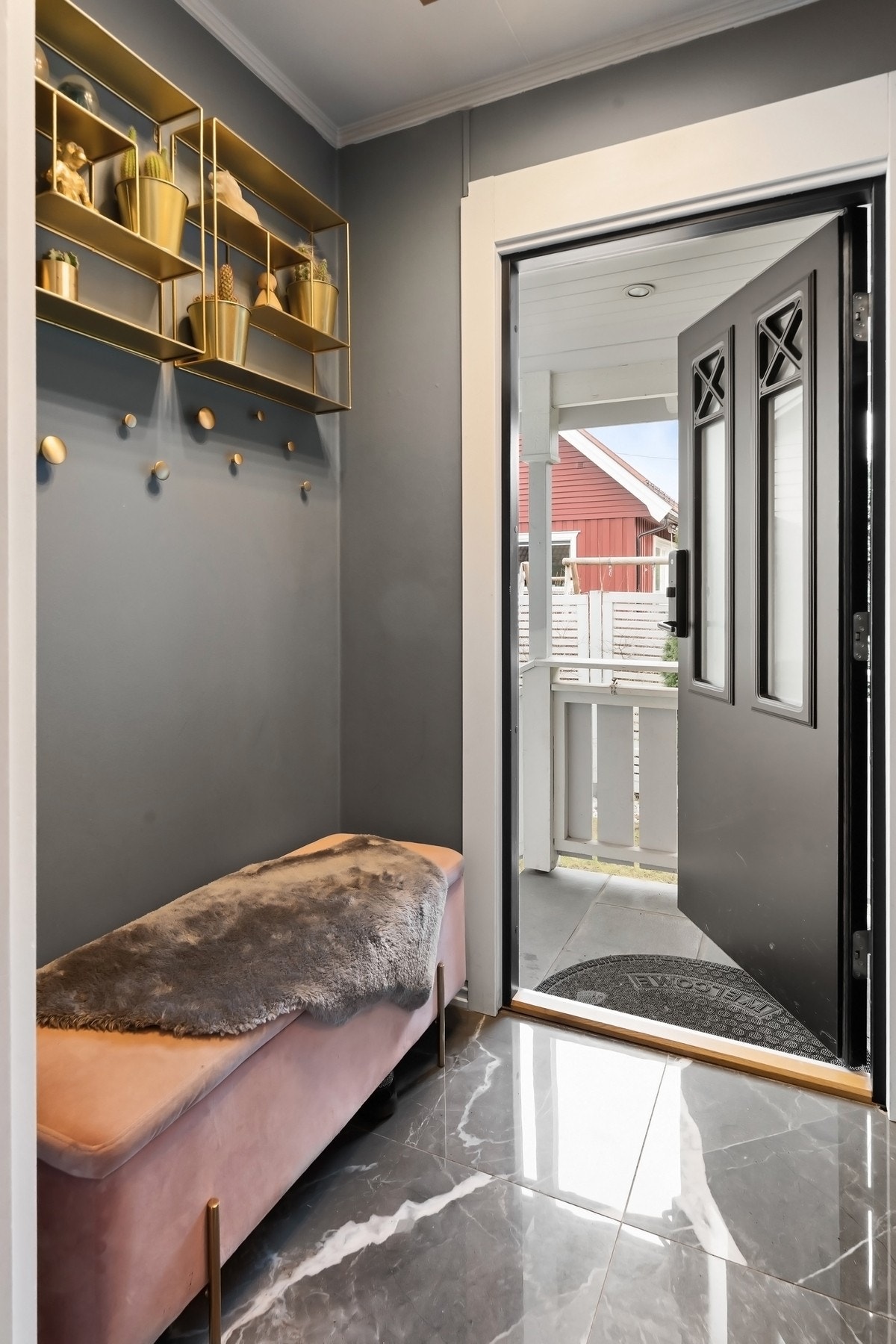 Vindfanget på innsiden har mørke, marmorerte gulvfliser, glatte vegger malt i en pen greigefarge. Det er kodelås på ytterdøren. Galleribilde