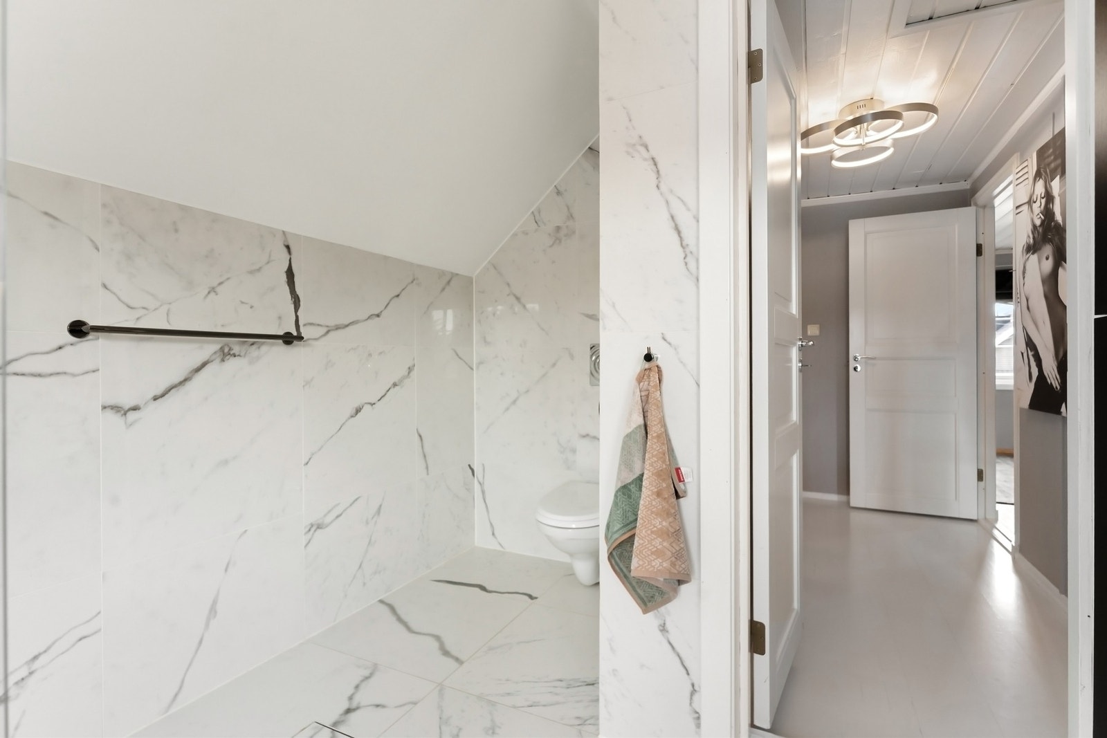 I motsatt ende av badet er det plassert et vegghengt toalett. Galleribilde