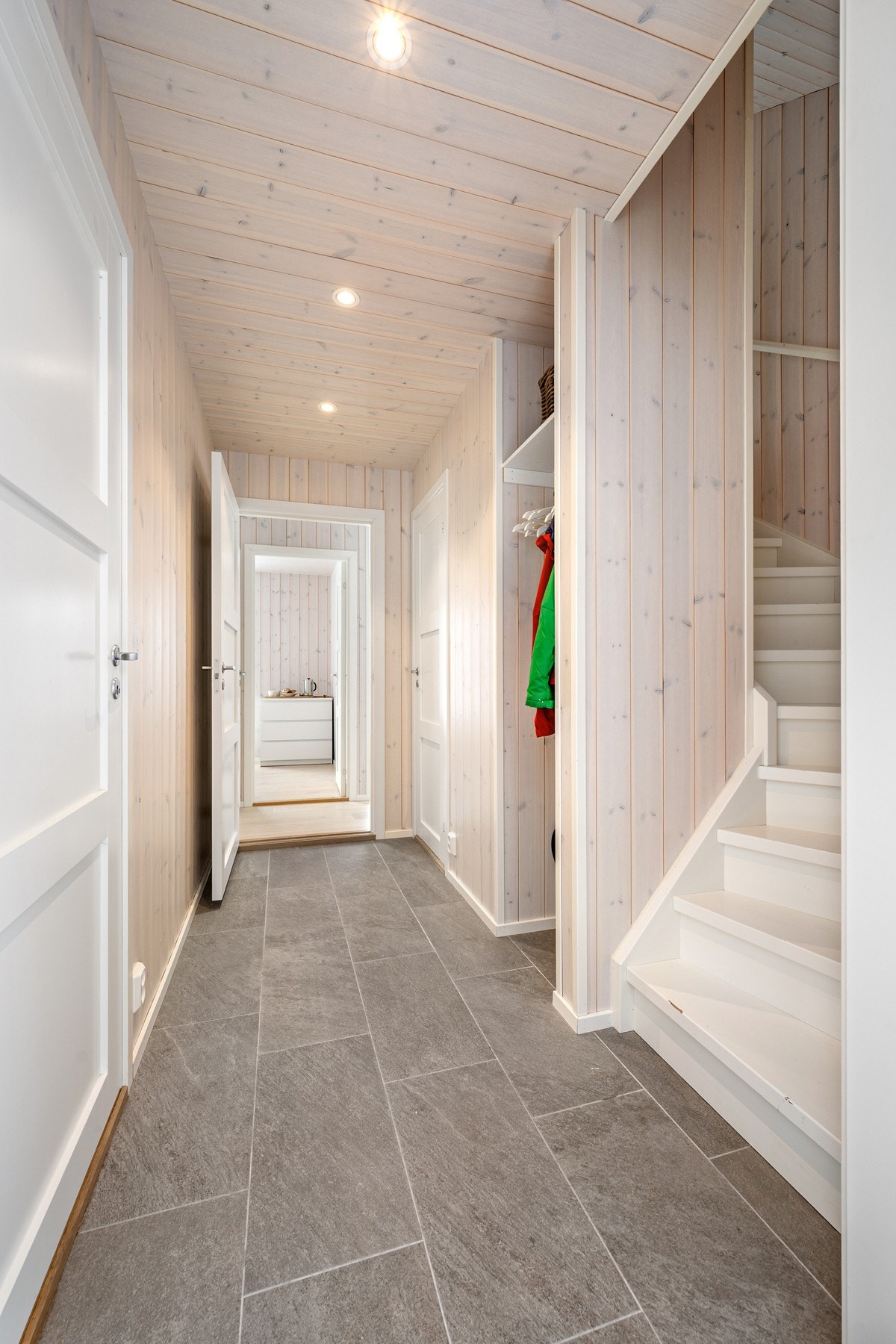 Flislagt entré med gulvvarme, og smart garderobeløsning ved siden av trapp Galleribilde