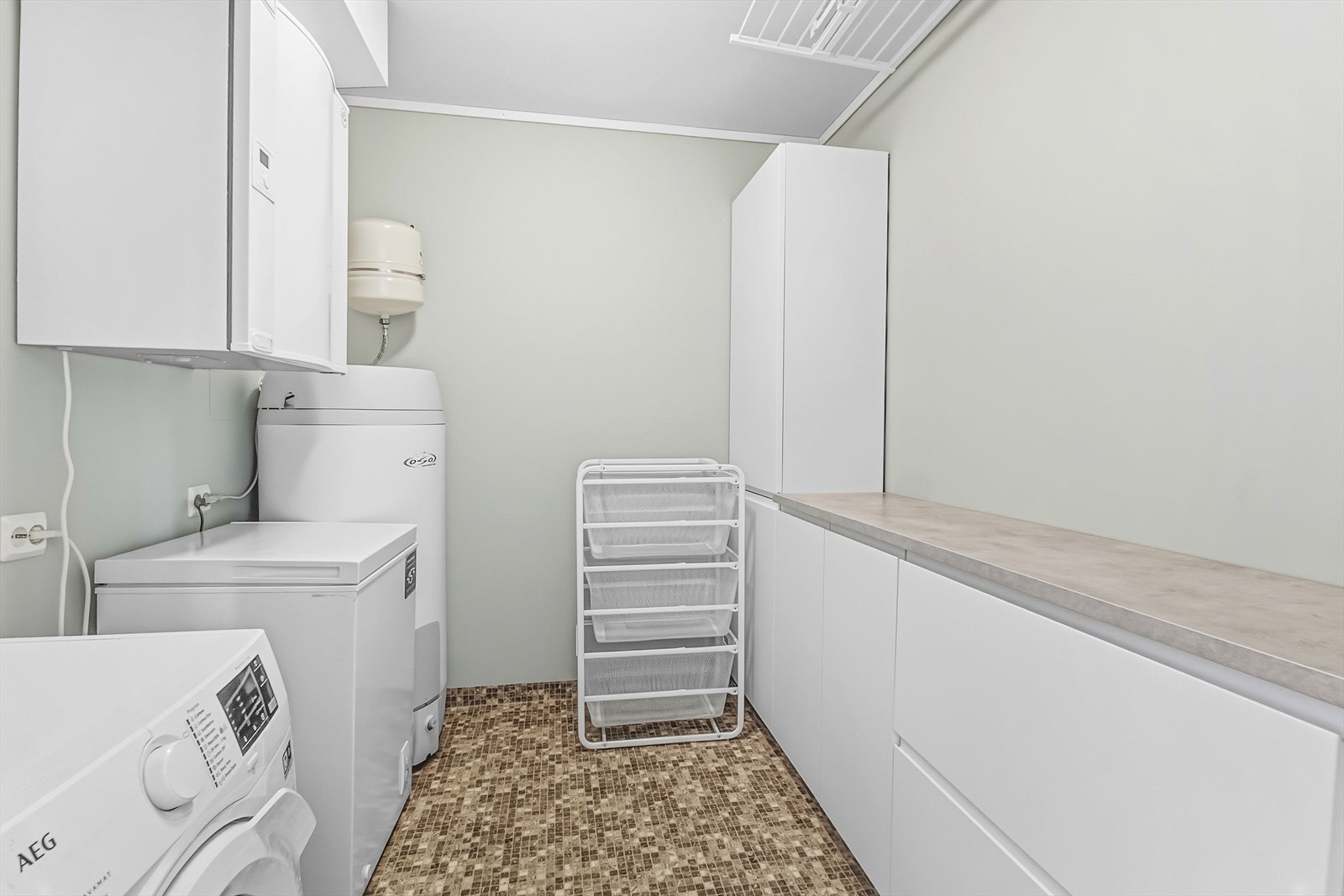 Vaskerom er svært praktisk med innredning hvor det er godt med oppbevaring i tillegg til arbeidsbenk. Galleribilde