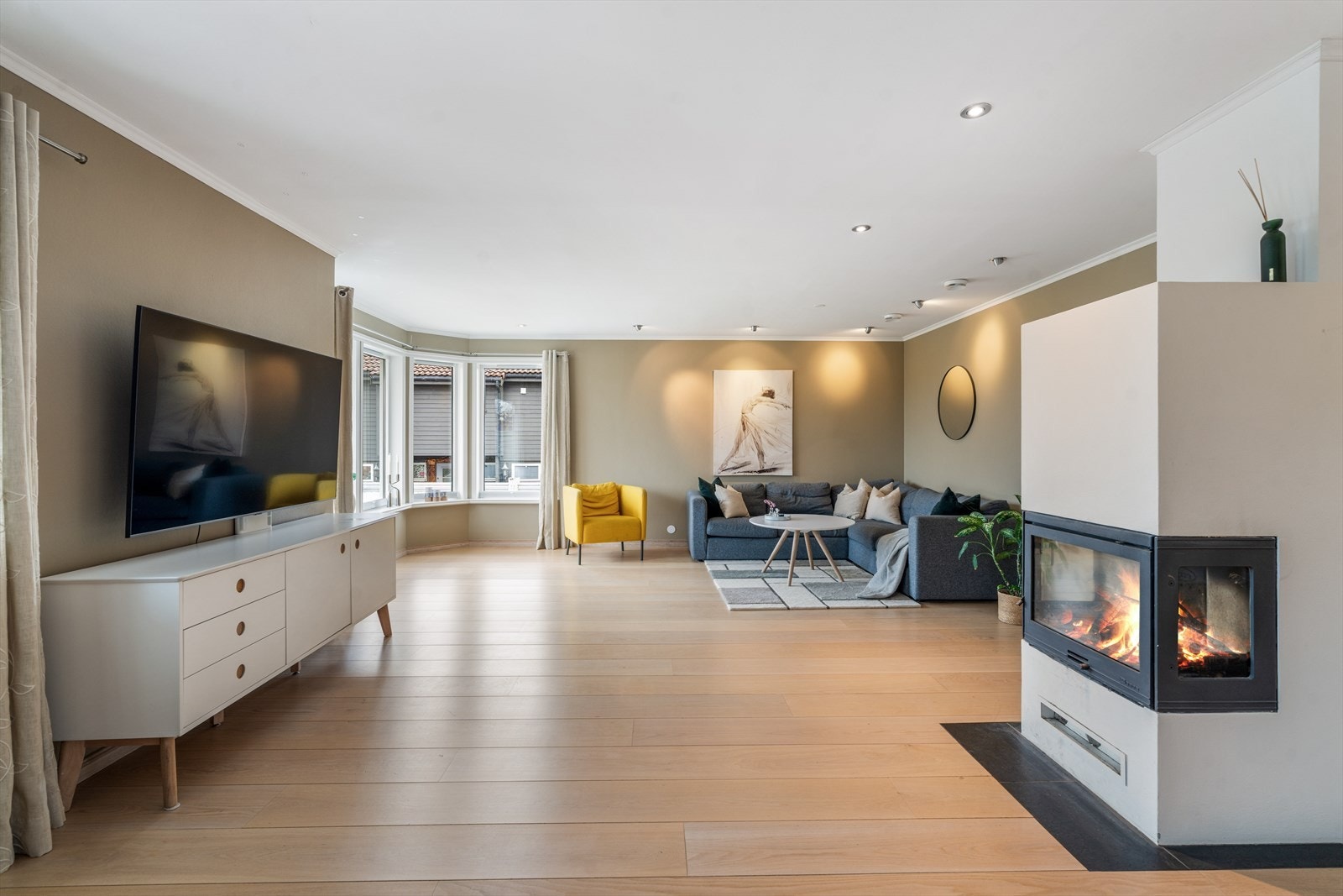 Rommet har god plass til flere sittegrupper og en sentralt plassert peisovn. Galleribilde