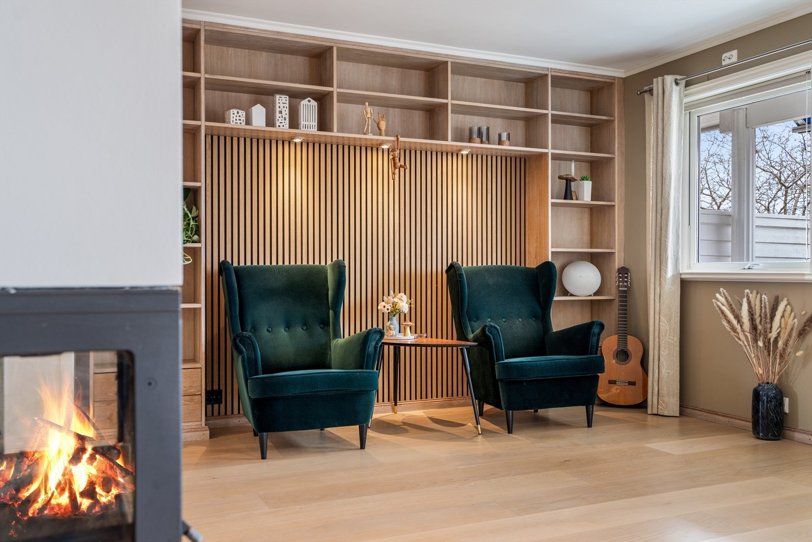 En del av stuen er innredet med en plassbygget bokhylle og en dekorativ spilevegg. Galleribilde