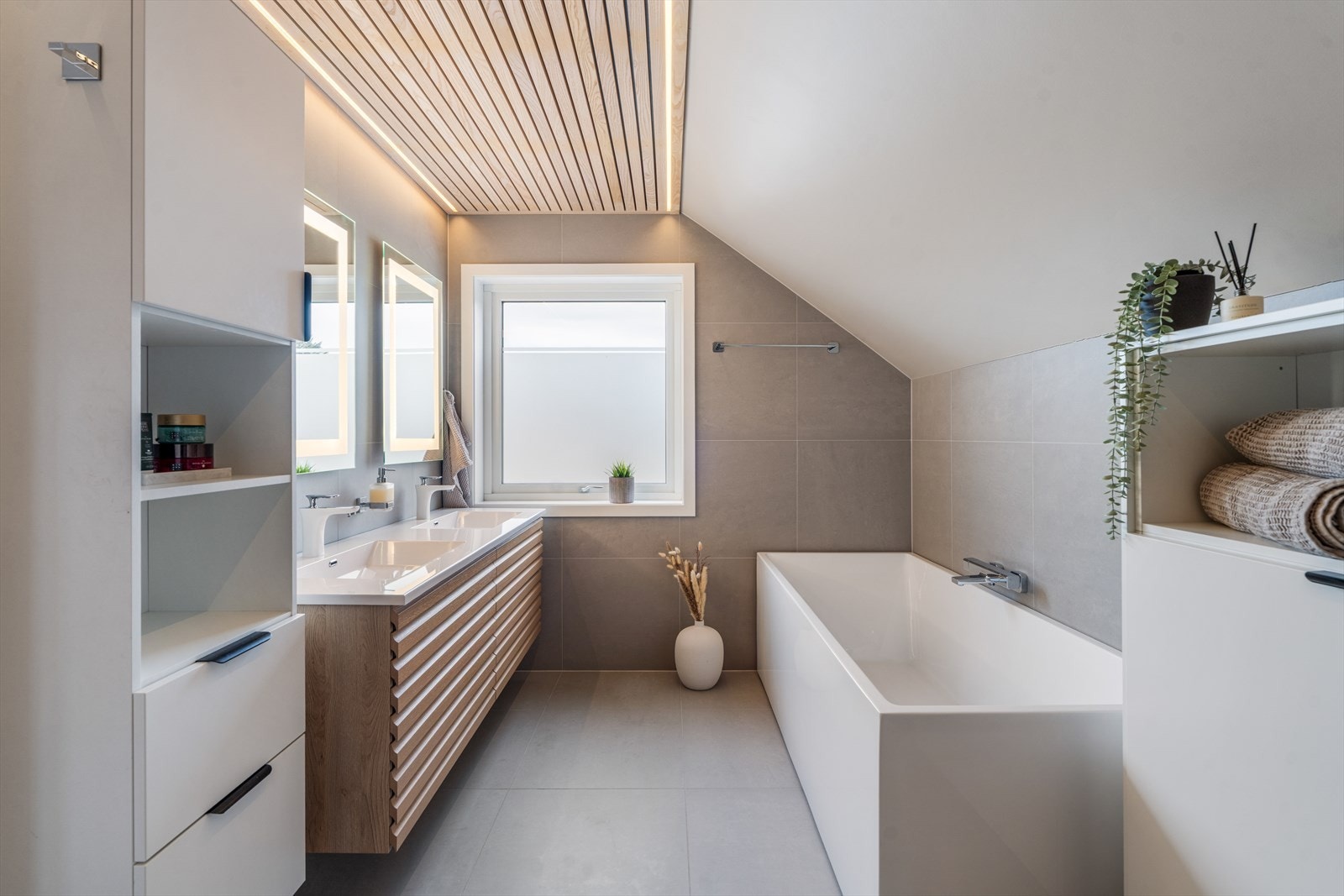 Hovedbadet er fra 2020, med delikate fliser, dobbel vaskseksjon og badekar. Galleribilde