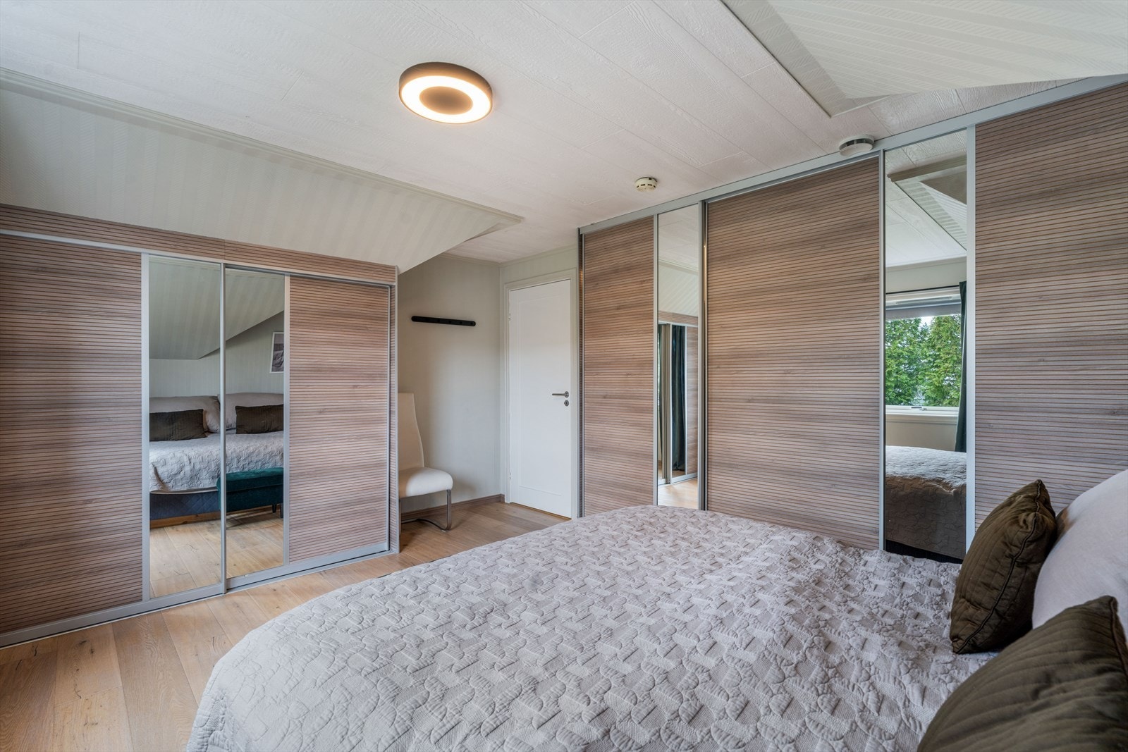 Her er det rikelig med garderobeplass i skyvedørsgarderober med speilfronter. Galleribilde