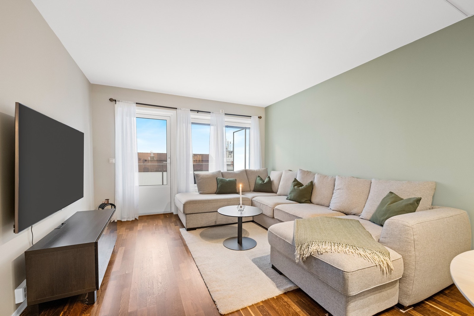 Stuen fremstår som lys og innbydende med en åpen løsning mot kjøkkenet, noe som skaper et sosialt og luftig oppholdsrom. Galleribilde