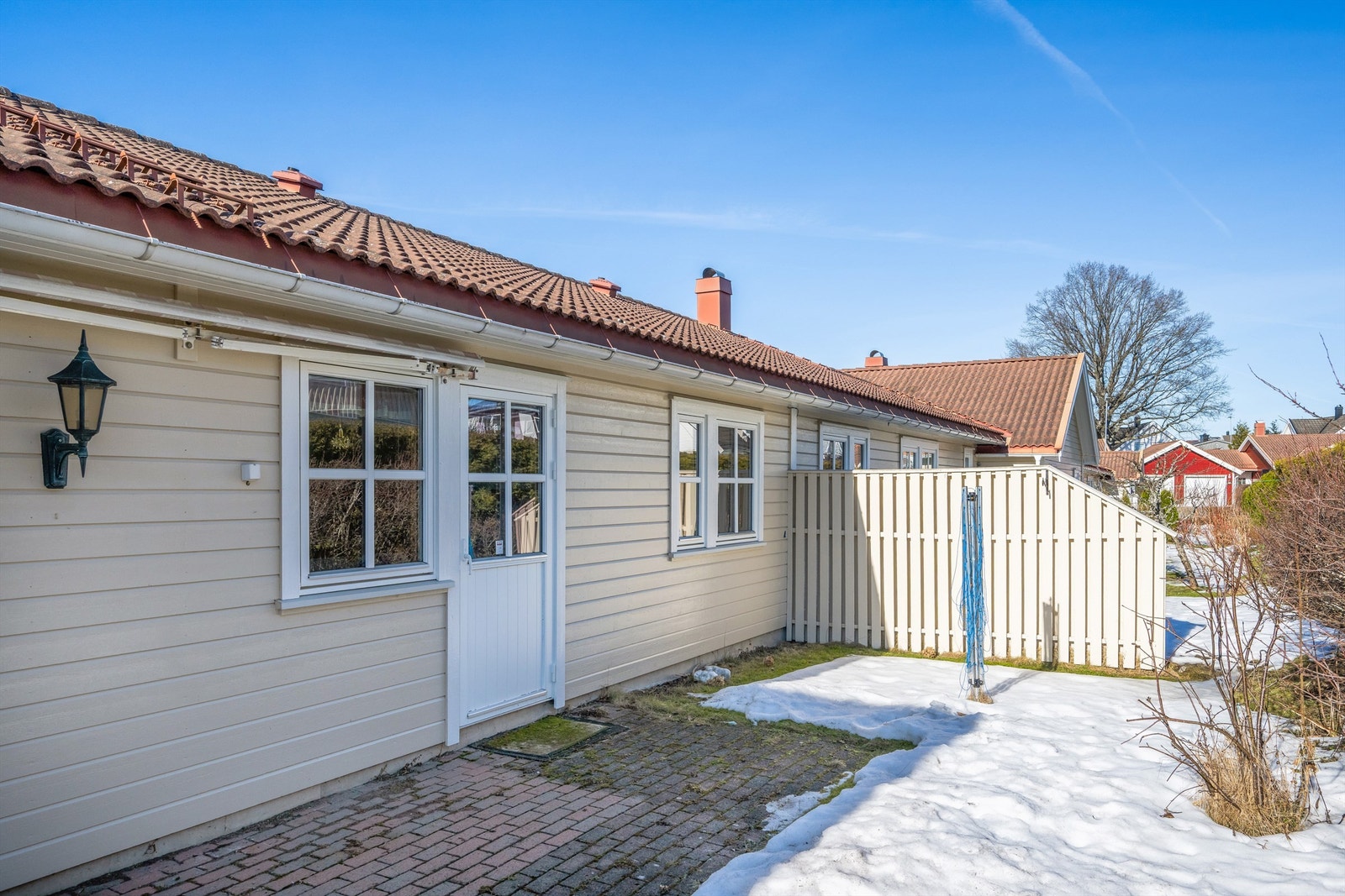 Den østvendte markterrassen ved kjøkkenet er belagt med belegningsstein. Galleribilde