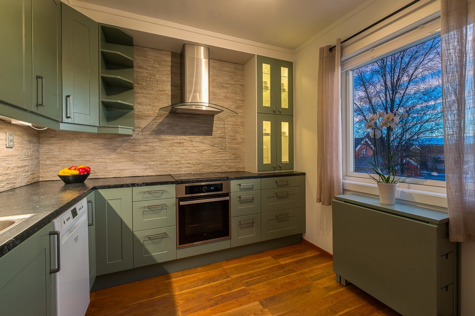 Kjøkkenet er innredet med frittstående oppvaskmaskin og kjøle/fryseskap og integrert stekovn Galleribilde