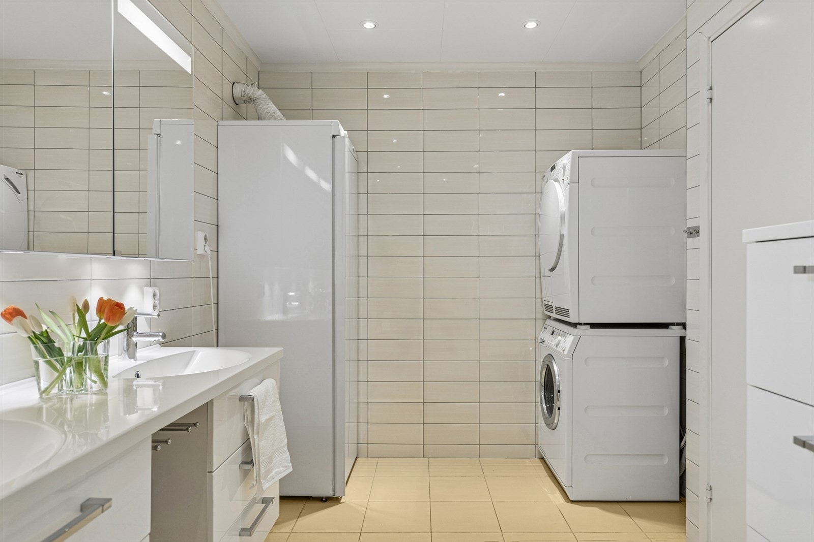 Baderom med opplegg til vaskemaskin. tørketrommel og tørkeskap. Galleribilde