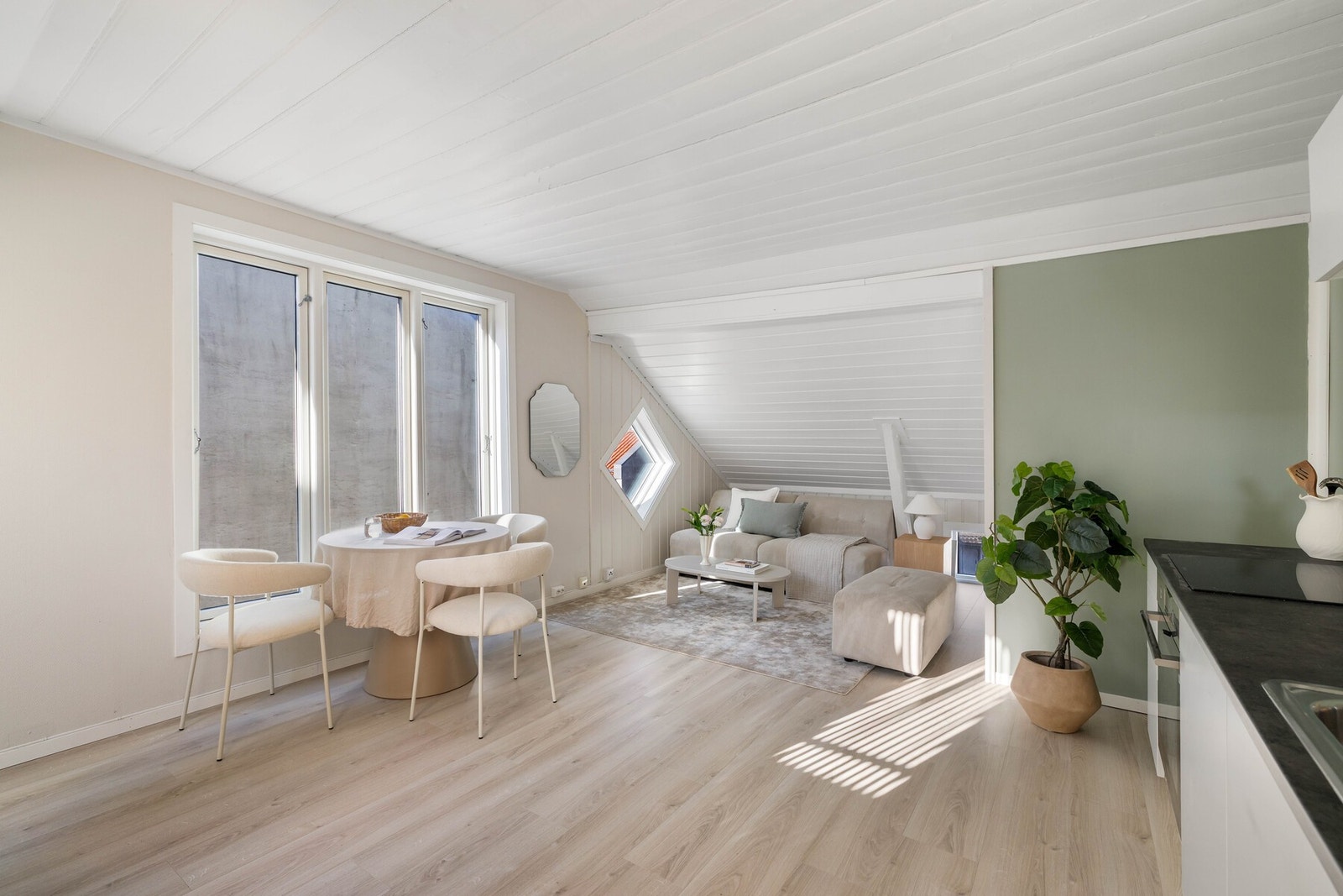 Boligens sosiale sone fremstår innbydende med lyse overflater og slitesterk laminat fra 2025. Galleribilde