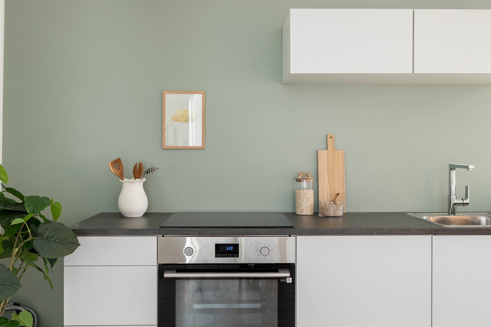 Stilren kjøkkeninnredning fra 2025 med slette fronter og laminat benkeplate med nedfelt oppvaskkum i rustfritt stål. Galleribilde