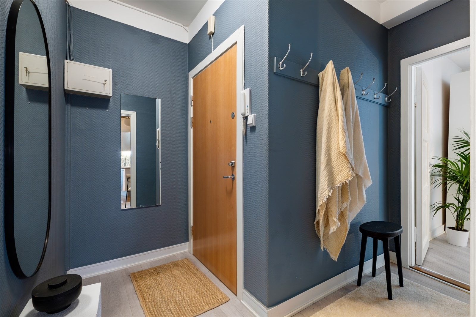 Velkommen inn! Innbydende entré med plass til sko og oppheng av yttertøy. Herfra er det adkomst til soverom og kjøkken. Galleribilde