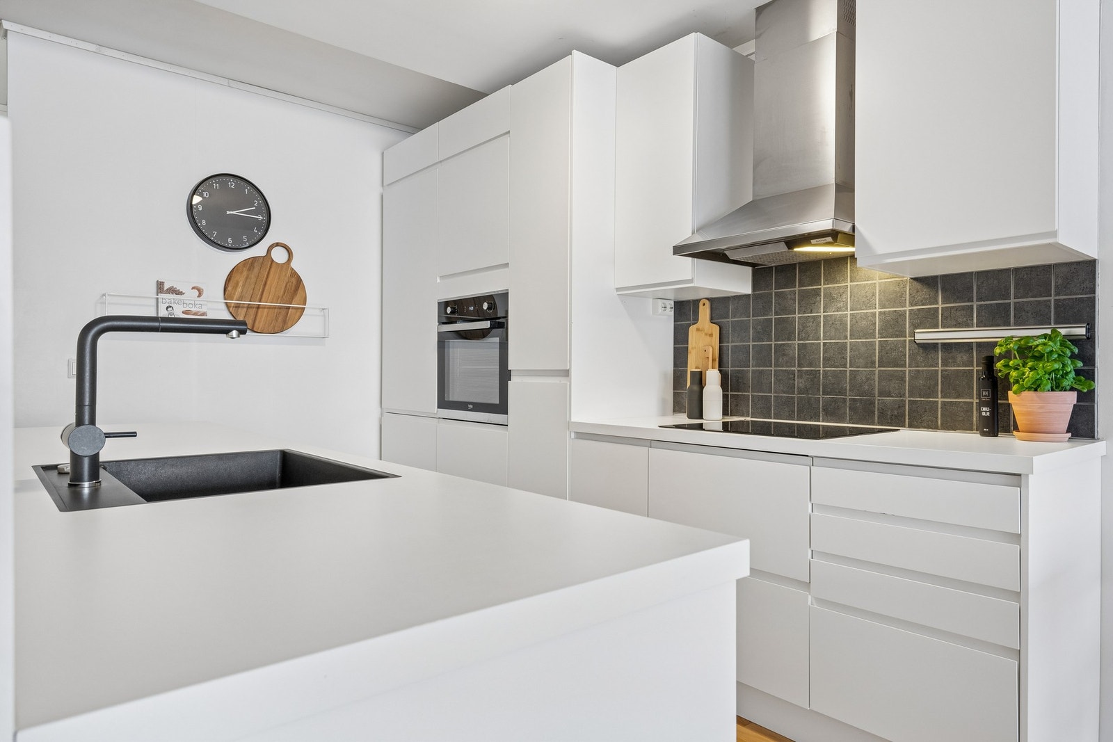 Stilrent hvitt kjøkken med moderne detaljer i sort Galleribilde
