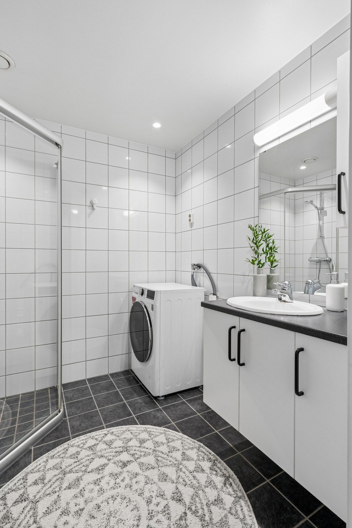 Badet er utstyrt med vegghengt innredning og opplegg for vaskemaskin Galleribilde