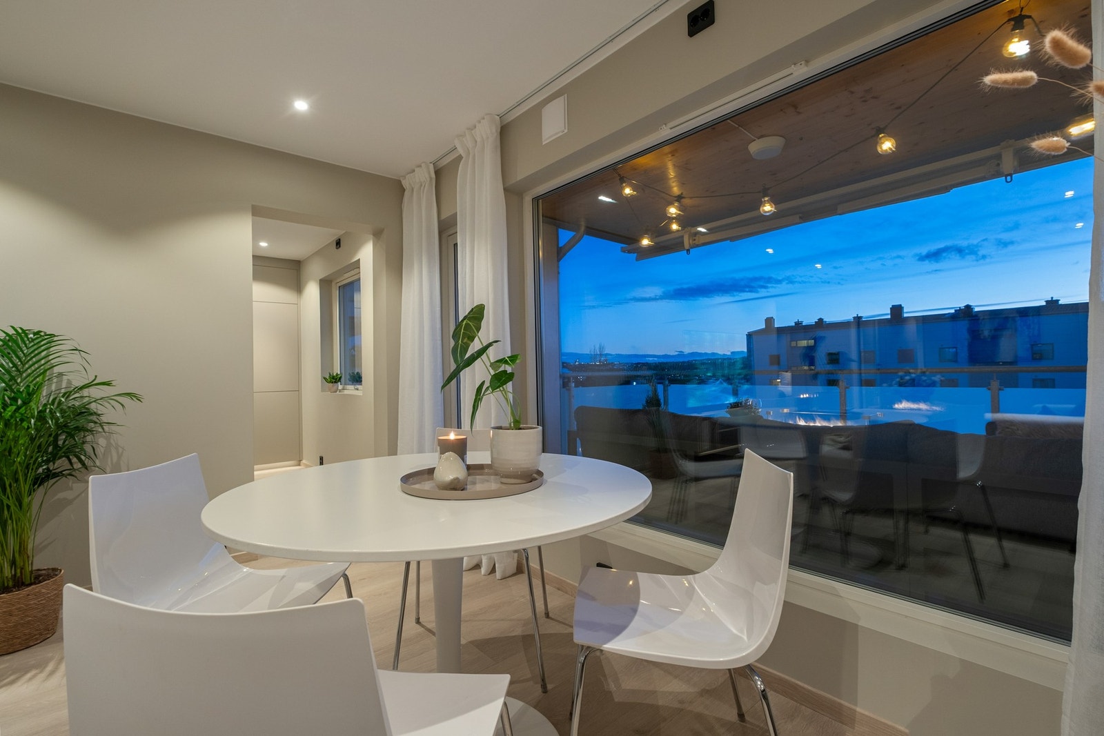 Store vindusflater i kombinasjon med lyse overflater og et lekkert gulv skaper en luftig og innbydende atmosfære Galleribilde