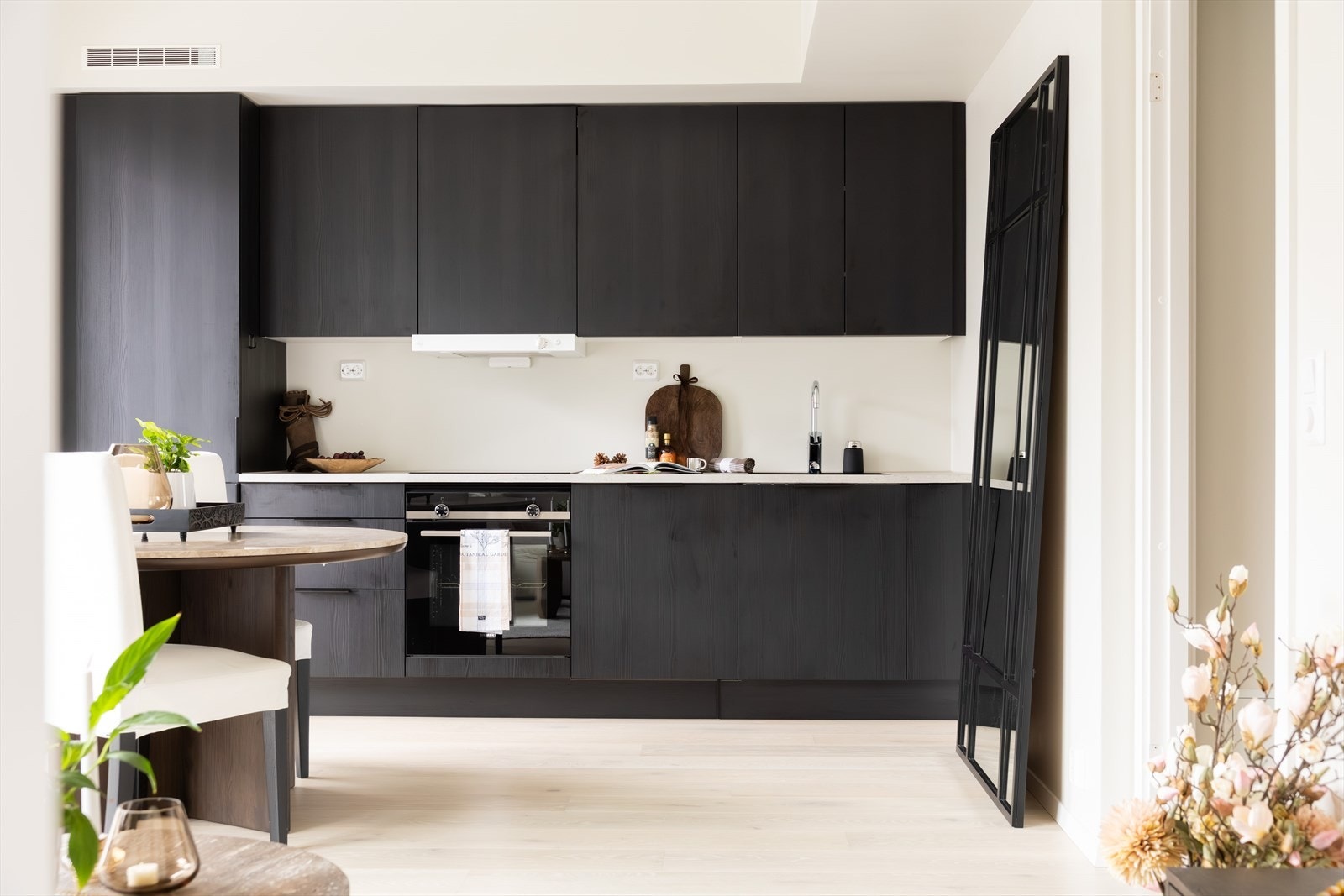 Kjøkkenet fremstår stilrent og moderne med glatte, mørke fronter som gir et tidløst uttrykk. Galleribilde