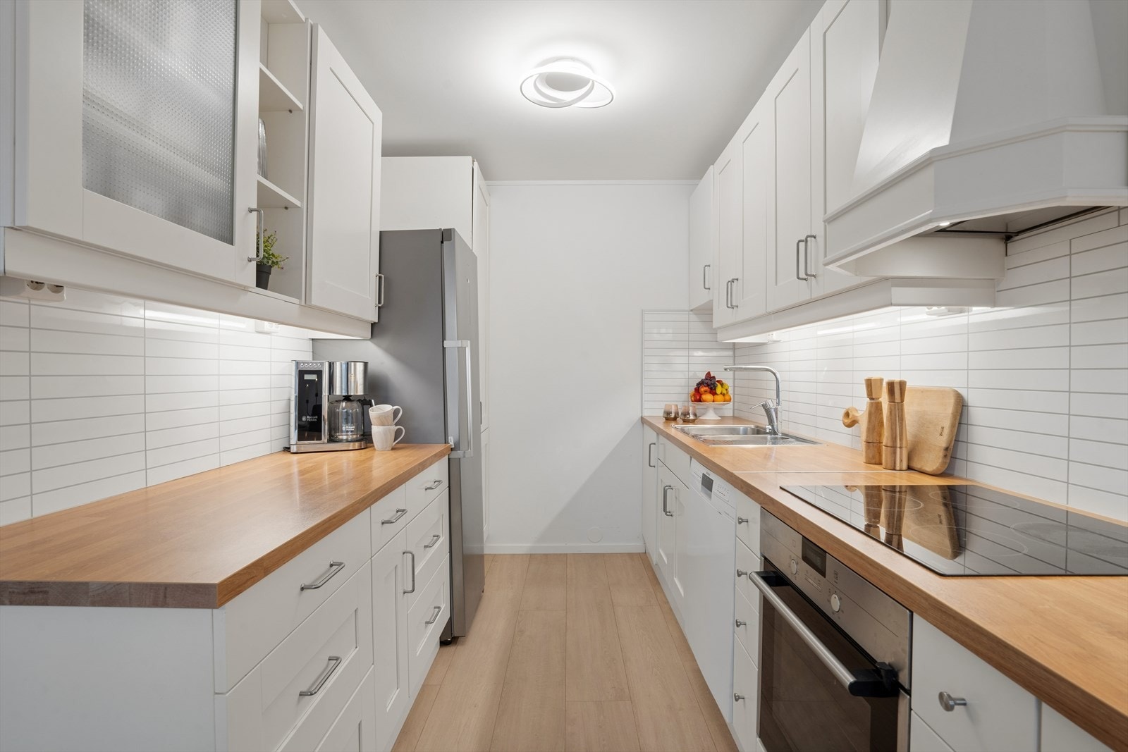 Fliser mellom benk og overskap, kombinert med LED-belysning som løfter uttrykket og gir godt arbeidslys. Galleribilde