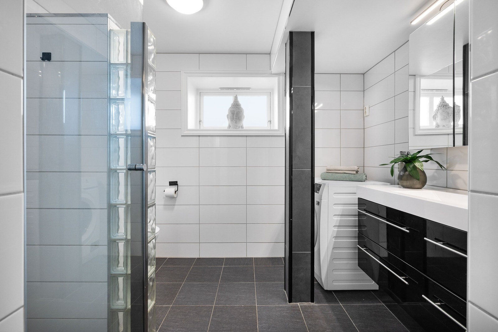 Pent, flislagt bad med nedfelt servant i innredning. Galleribilde