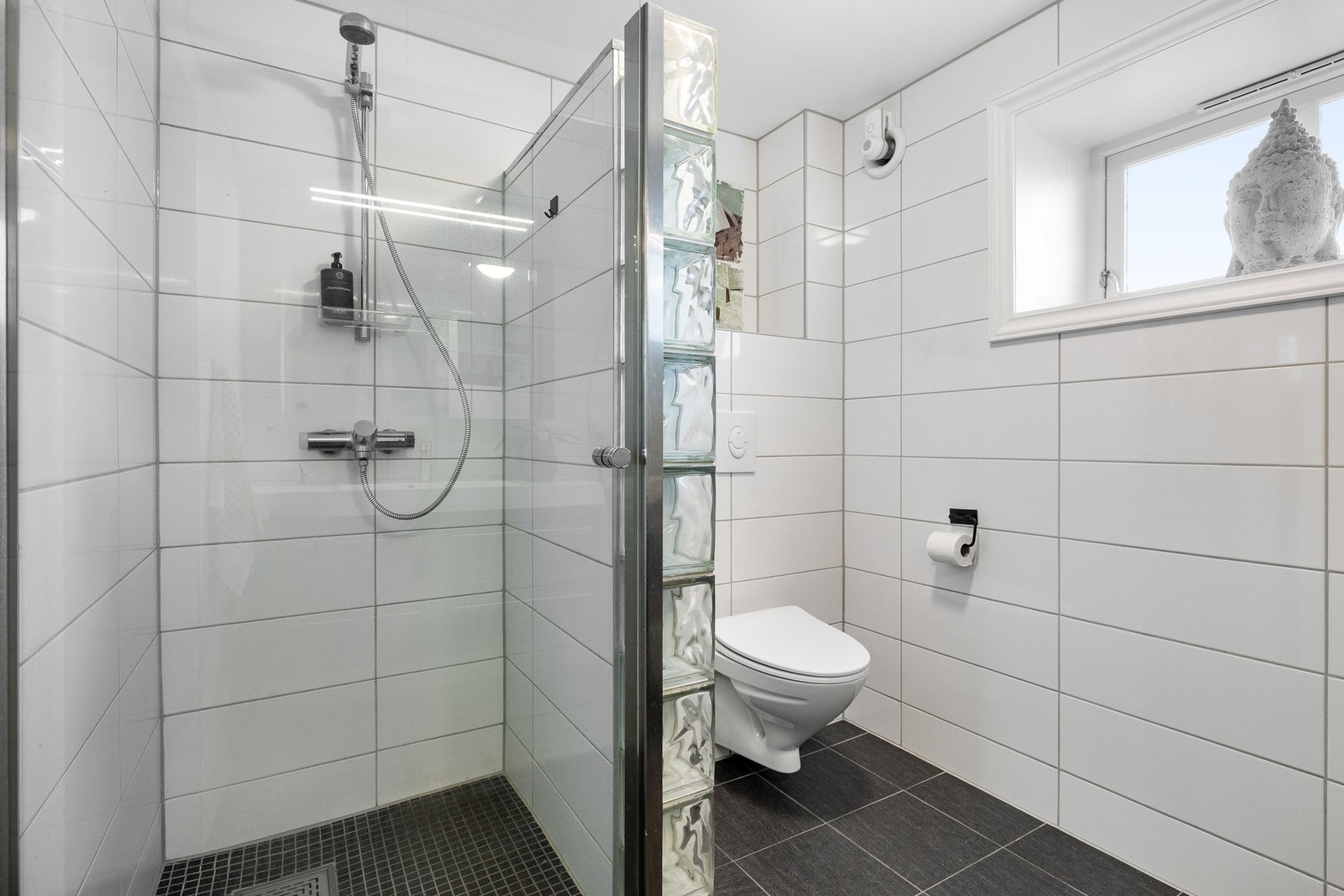 Romslig dusjnisje og vegghengt toalett. Galleribilde