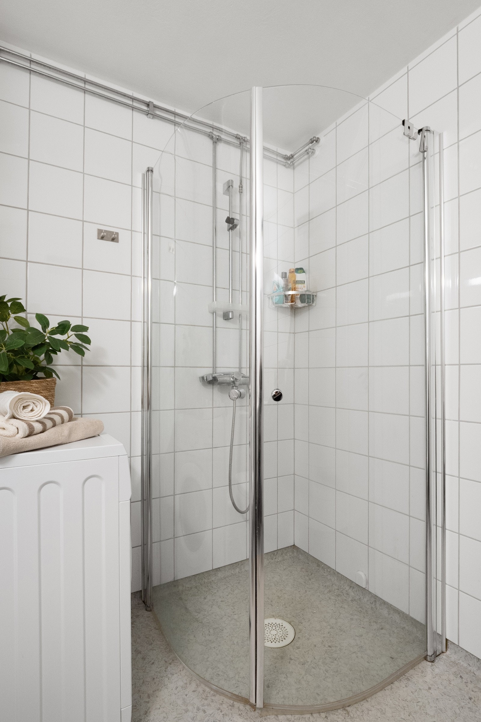 Badet er utstyrt med dusjhjørne med innfellbare dusjvegger, lys baderomsinnredning med heldekkende servantplate samt opplegg for vaskemaskin. Galleribilde