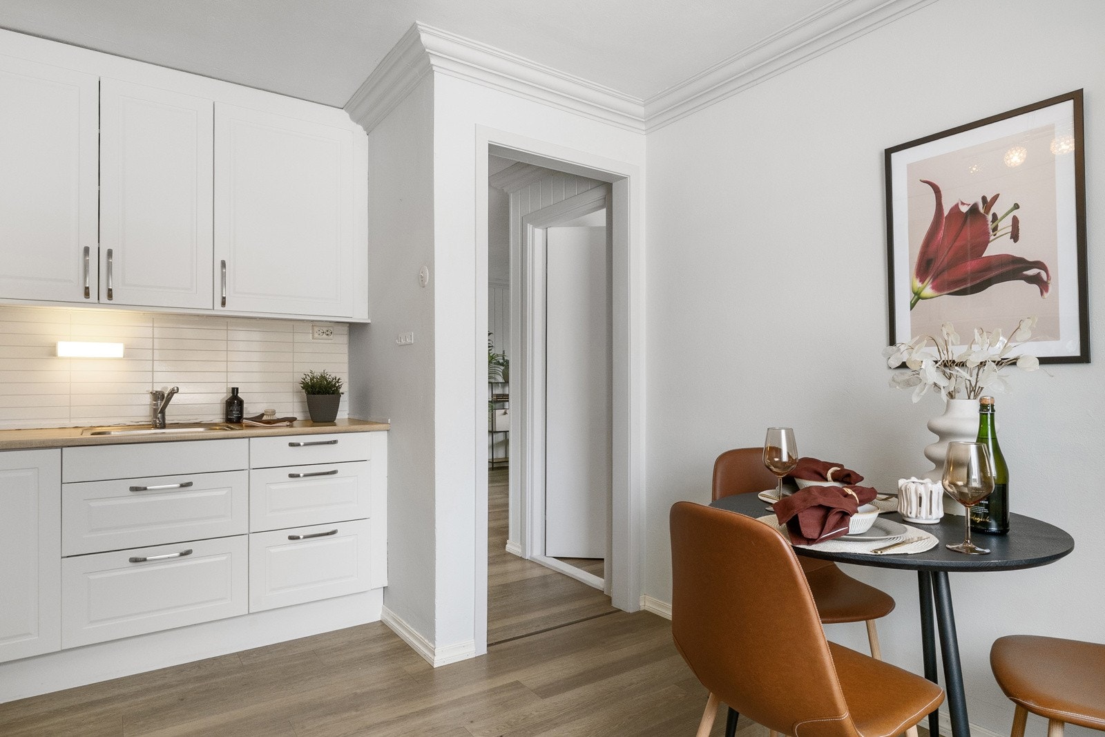 Stort kjøkken med lyse, profilerte fronter og laminert benkeplate med kitchenboard i benkerygg. Galleribilde