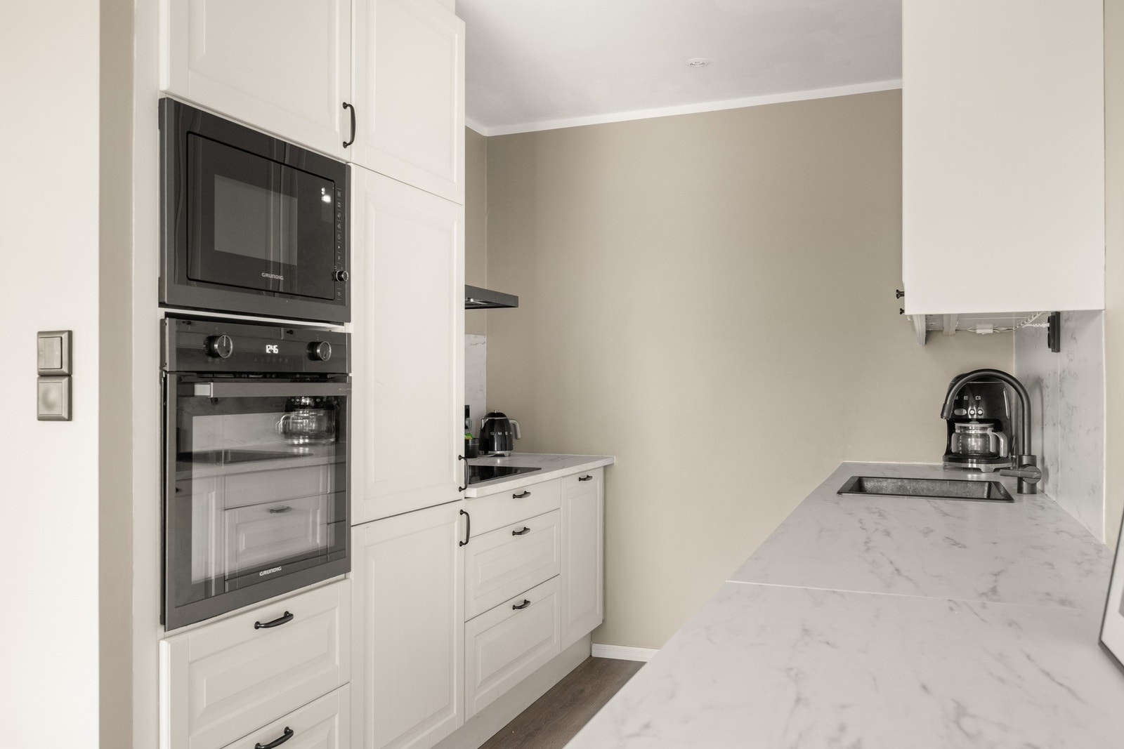 Kjøkkeninnredningen består av lekre profilerte fronter, laminat benkeplate, over benkeplaten er det benyttet laminatplate, oppvaskkum og ventilator. Galleribilde