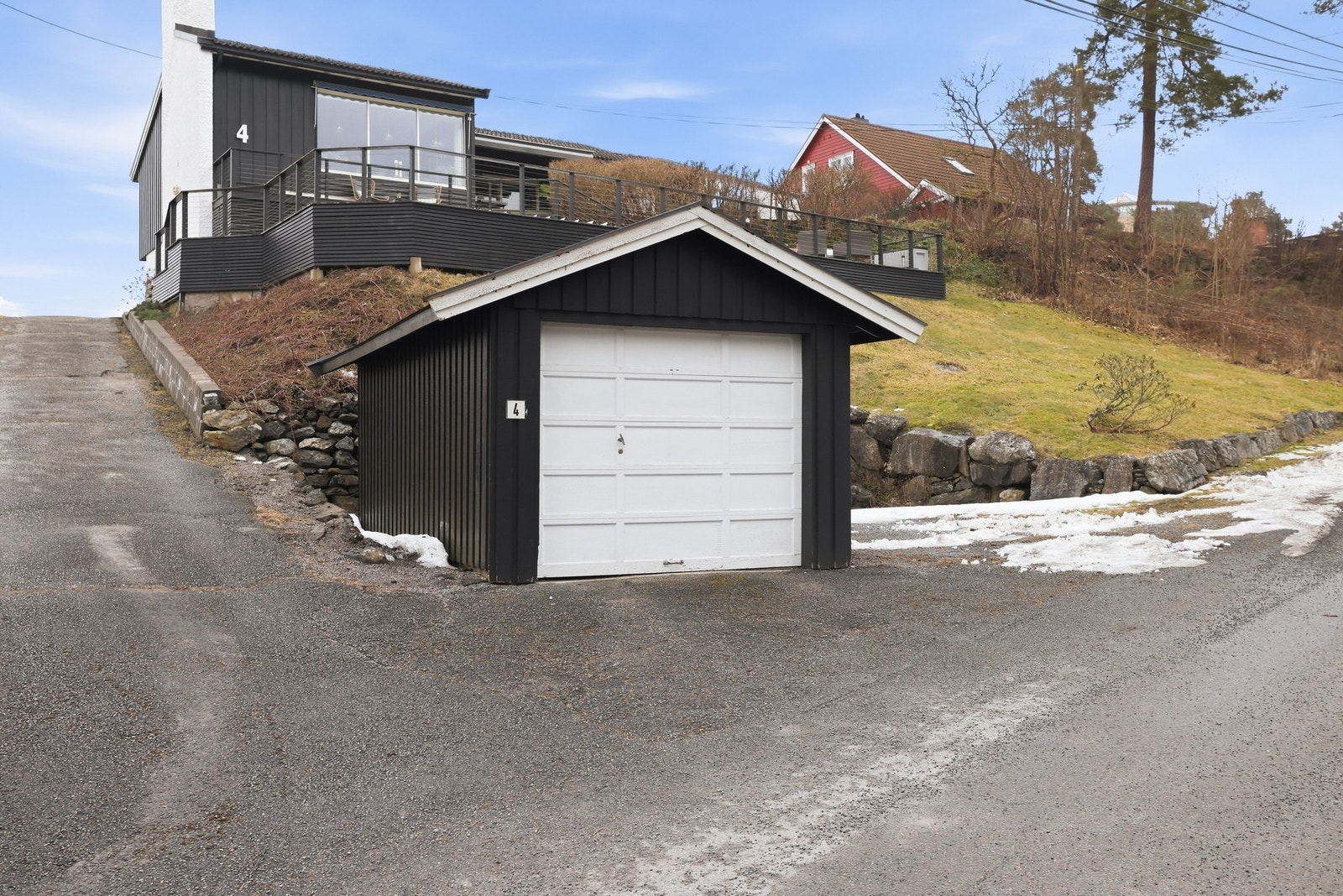 Garasje med plass til en bil med biloppstillingsplass ved siden av garasjen Galleribilde