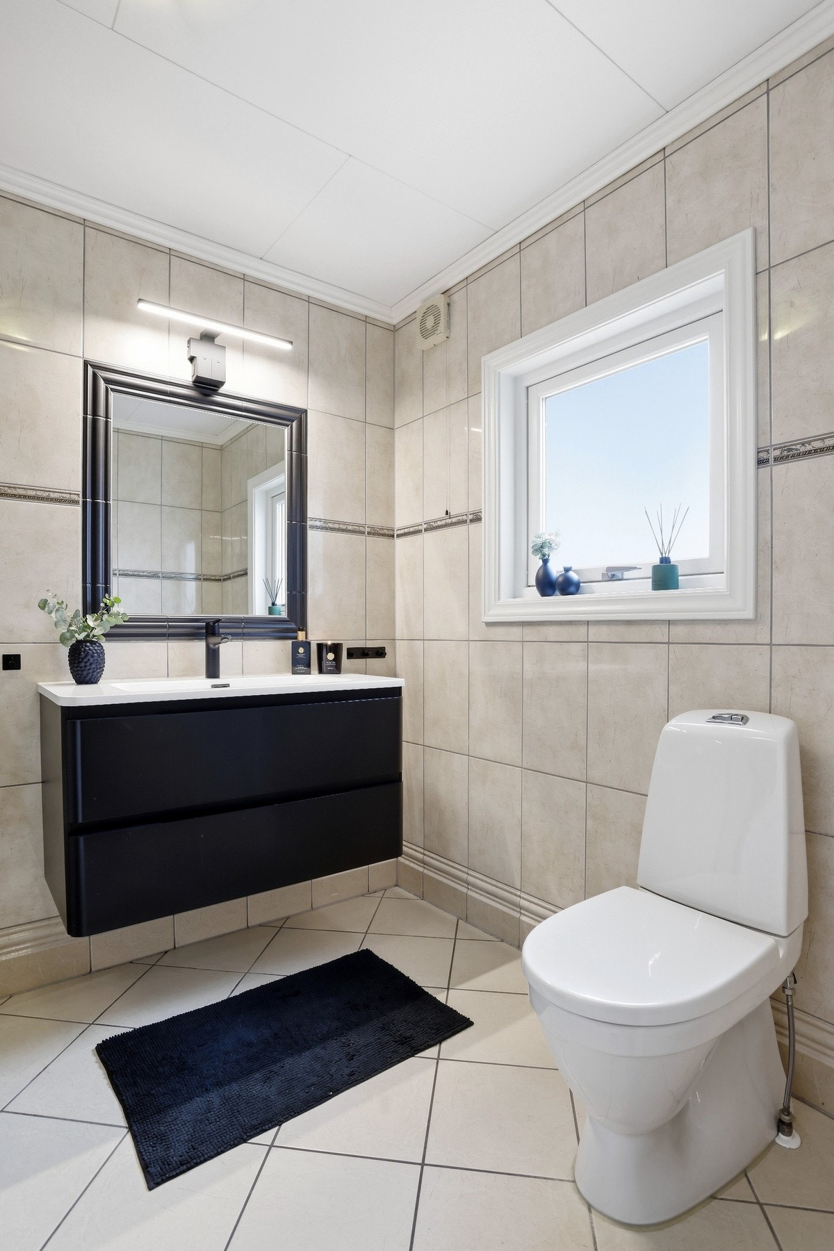 Dusj, gulvmontert toalett og baderomsinnreding med servant og speil i vegg Galleribilde