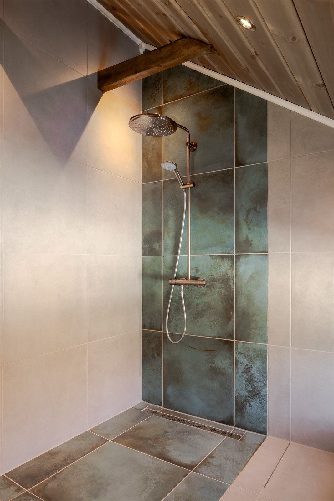 Dusjhjørne med lekre fliser, designsluk og vegghengt armatur med både hånd- og regnfallsdusj. Galleribilde