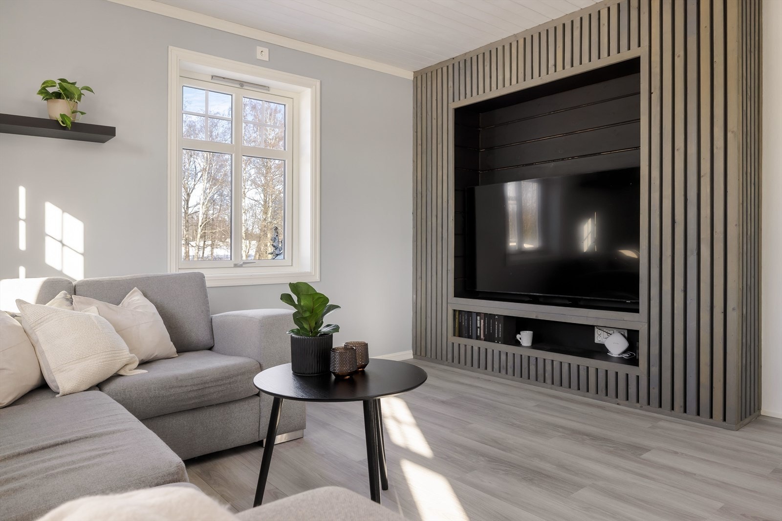 Naturlig plass til tv-en i en flott plassbygget løsning av dekorative trespiler. Galleribilde