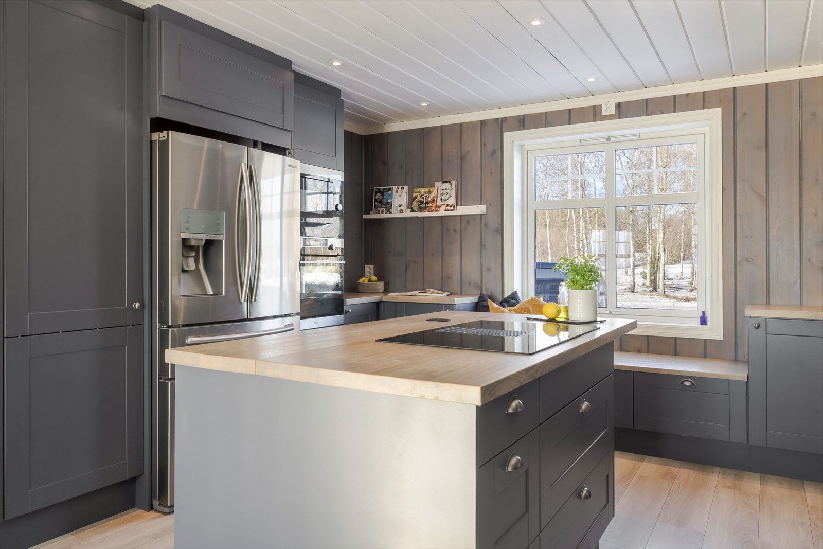 Kjøkkenet har en praktisk utforming med en stor kjøkkenøy i midten - her har du masse skap- og benkeplass! Galleribilde