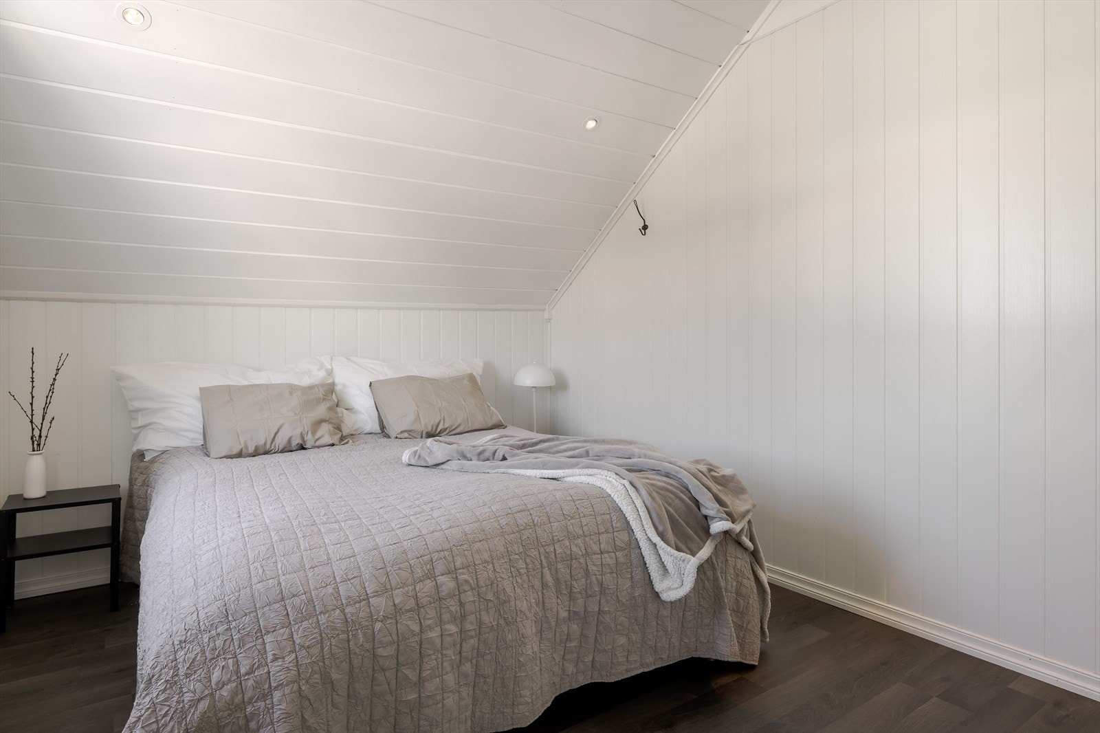 Soverommet har mørk laminat på gulv, lyse panelplater på veggene, skjult elektrisk anlegg og innfelte downlights i himlingen. Galleribilde