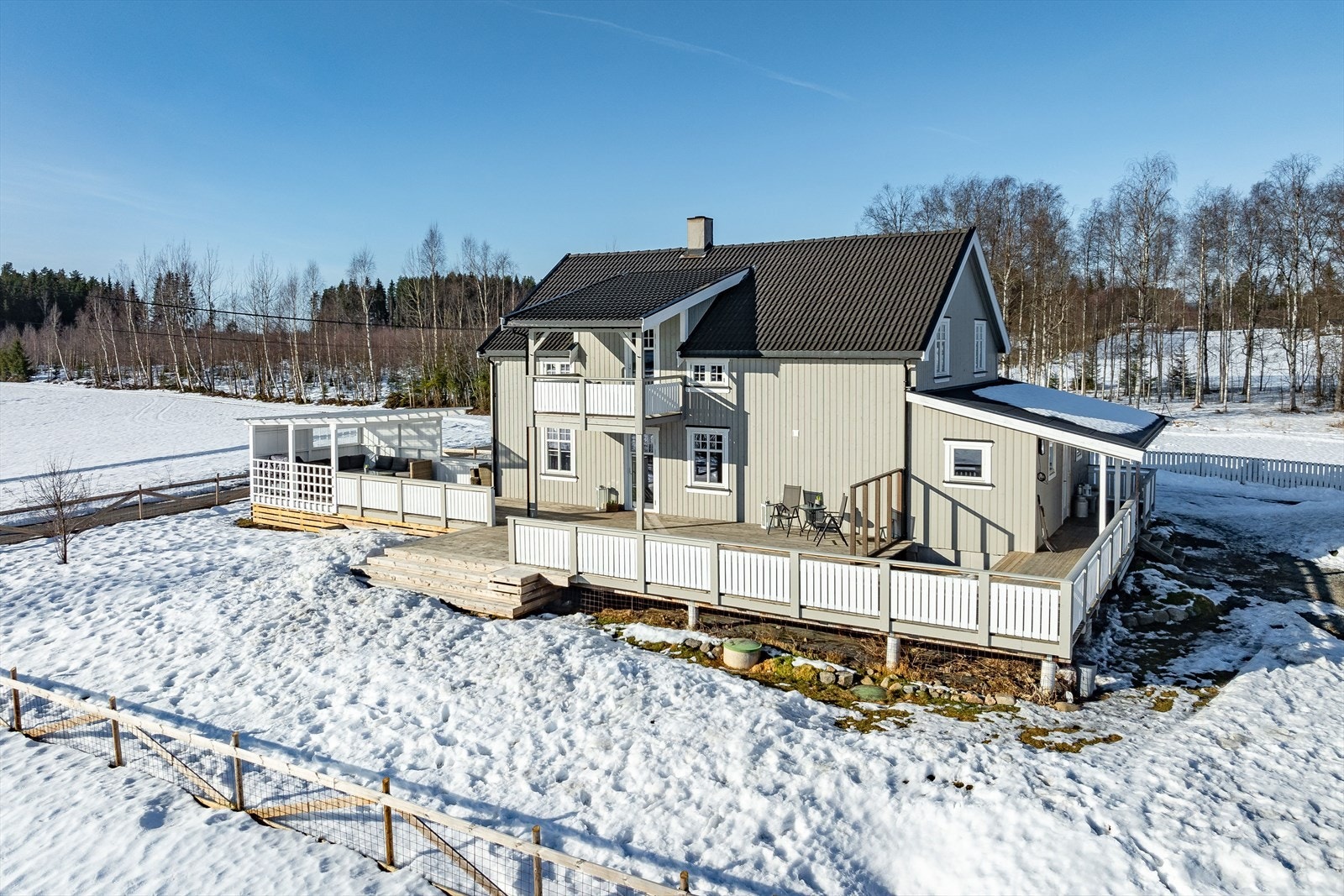 Utenfor huset er det en stor og solrik terrasse på ca. 122m² med pergola i den ene enden, samt et fint uteområde opparbeidet med plen. Galleribilde
