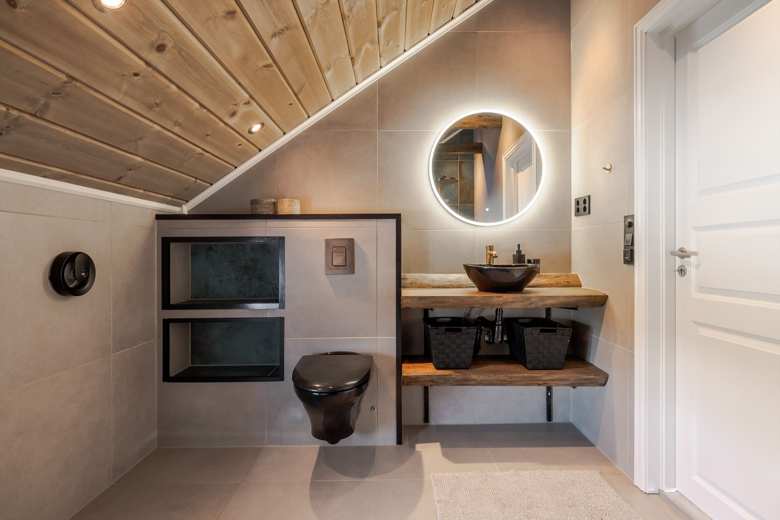 Flott baderomsinnredning av massive trehyller og ovenpåliggende bolleservant, rundt speil med integrert belysning over. Galleribilde