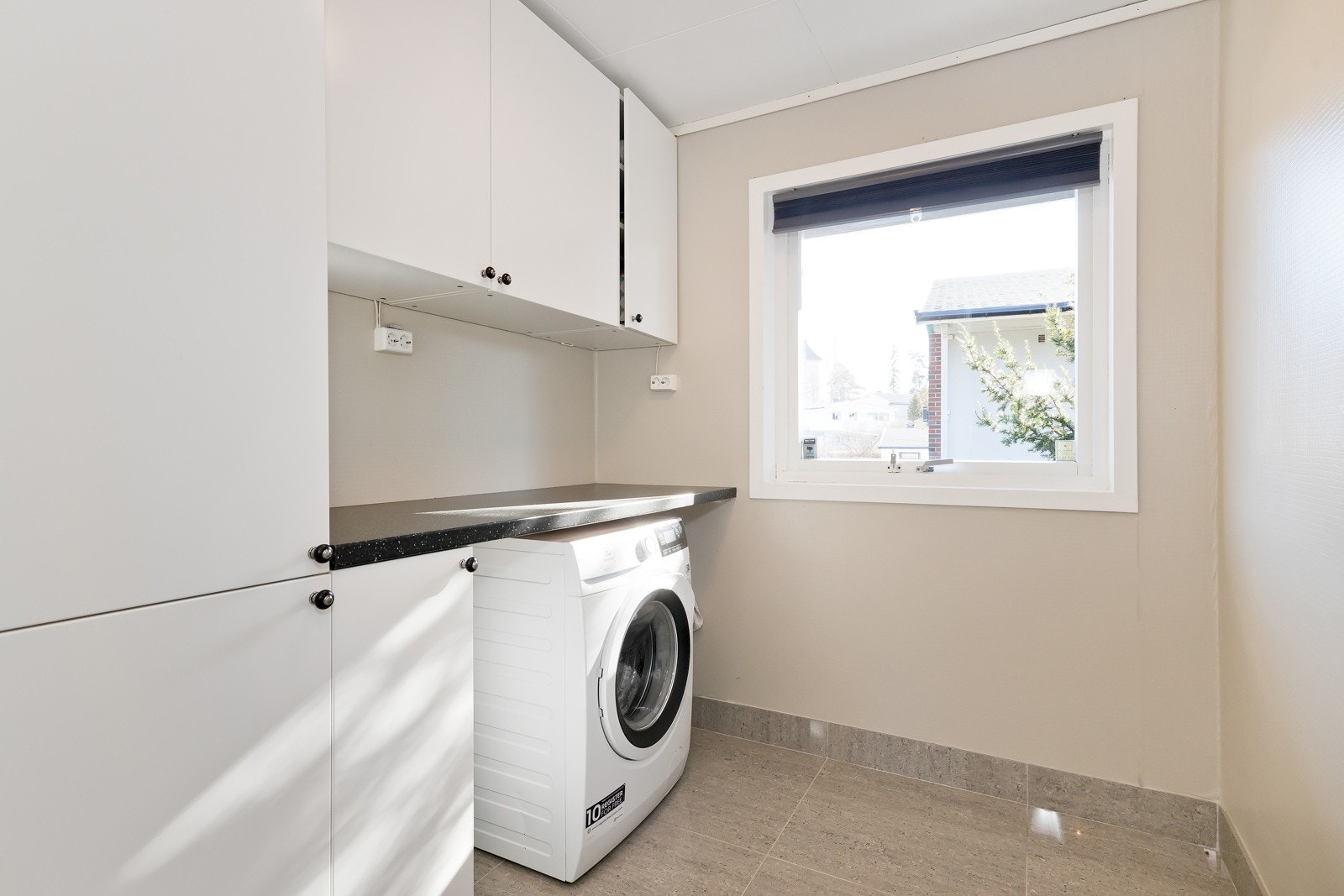 Rett inn fra entreen har man også et romslig og praktisk vaskerom med opplegg for både vaskemaskin og tørketrommel Galleribilde