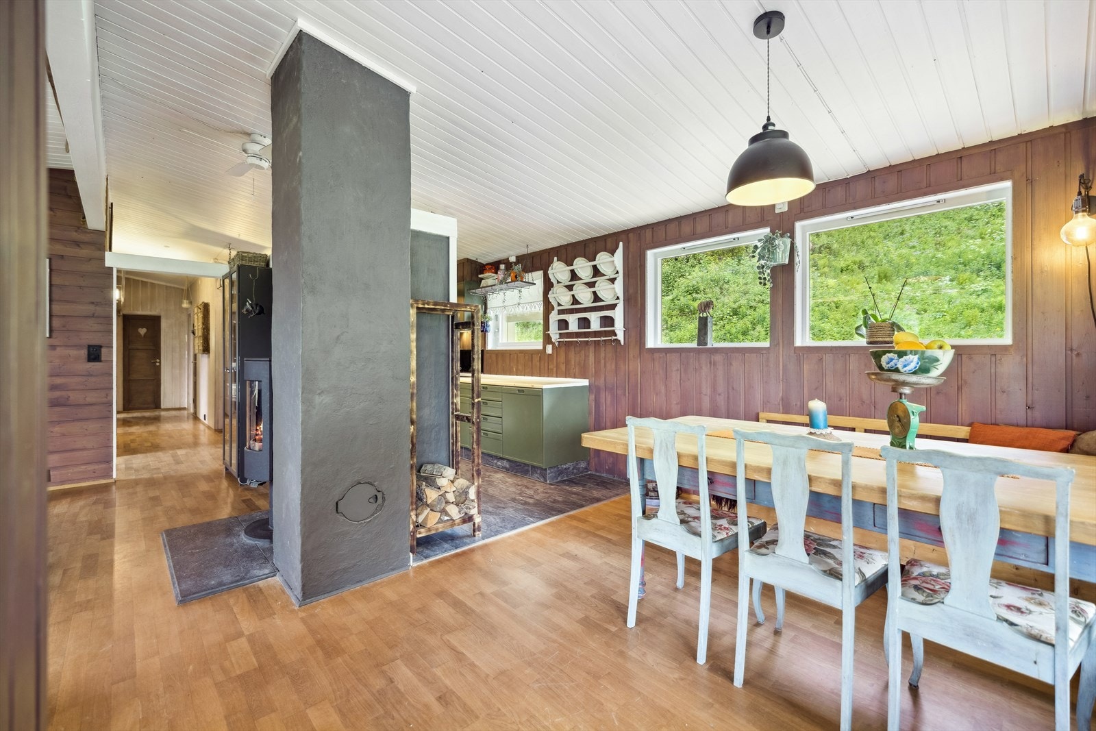 Spisestue med plass til langbord, omgitt av panelvegger og store vinduer. Galleribilde