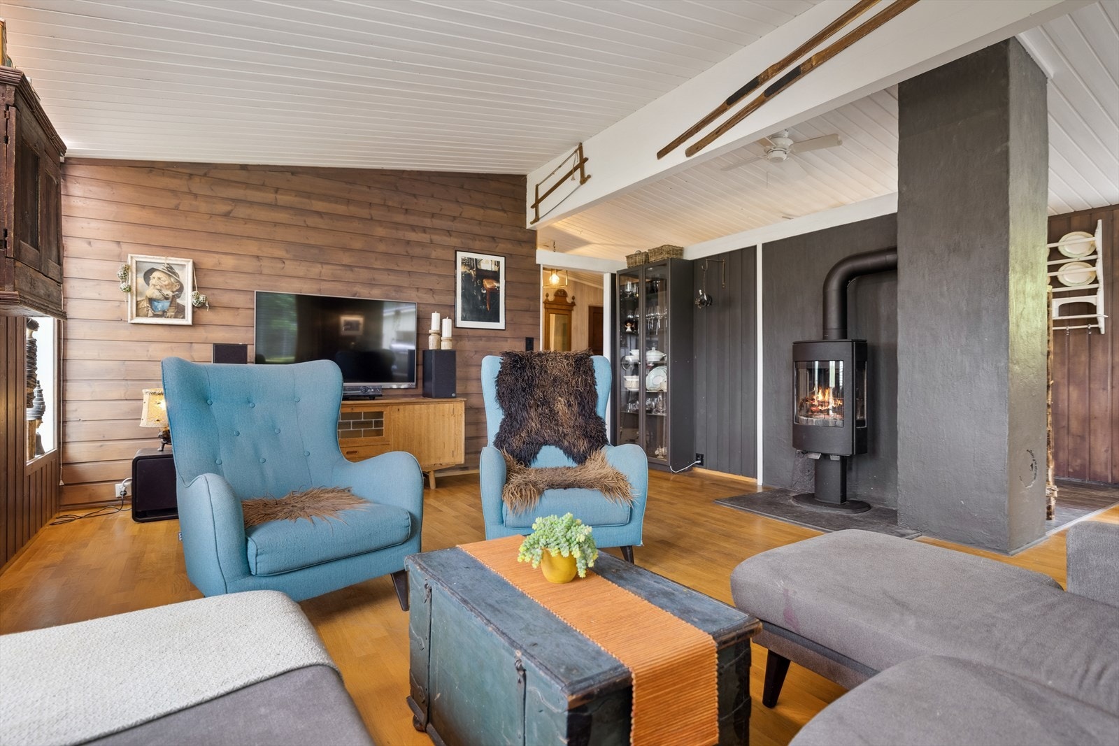 Stuen har plass til stor sofagruppe og gir en lun atmosfære med panelvegger Galleribilde