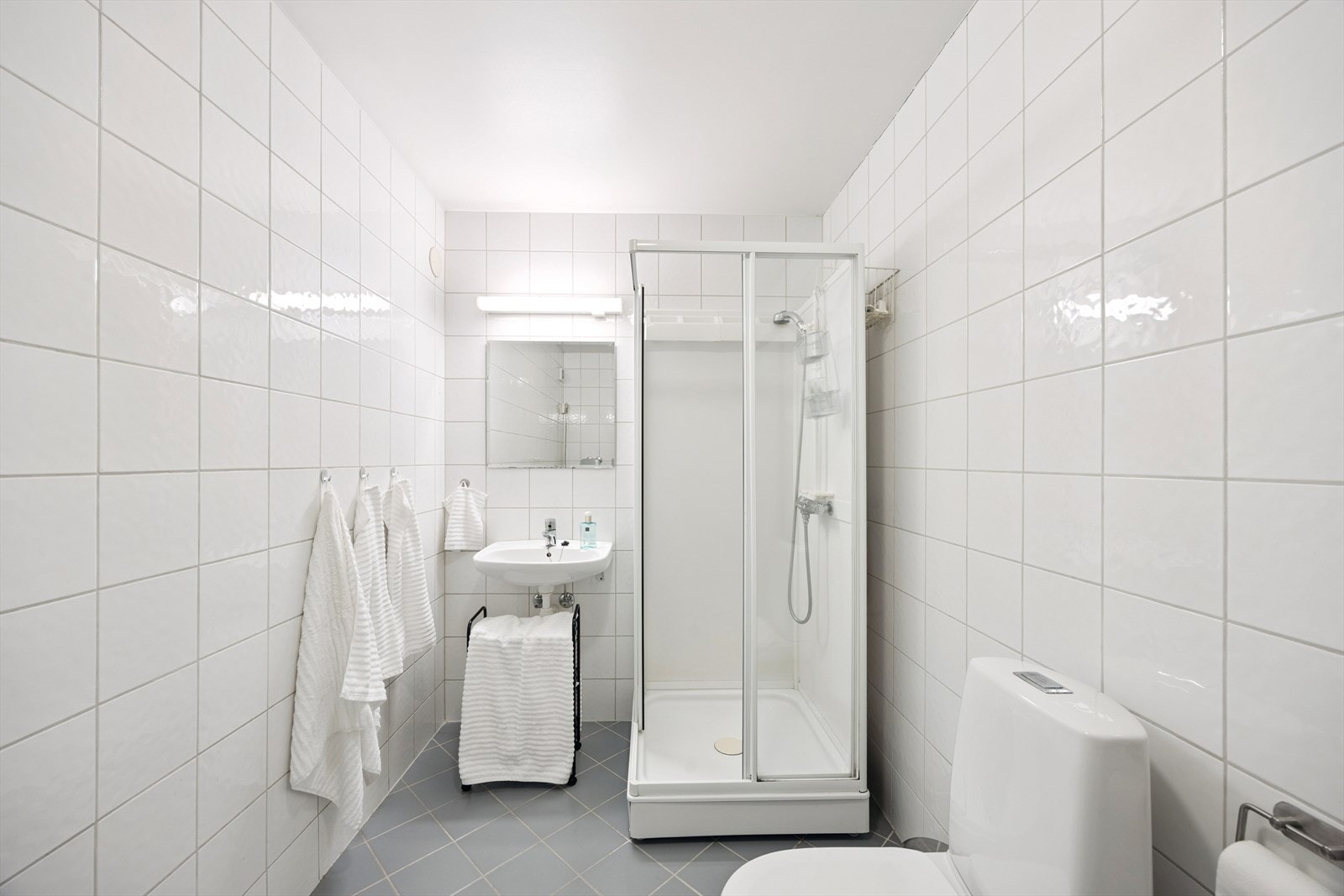 Utleiedel: Pent flislagt bad med gulvvarme. Badet er utstyrt med dusjkabinett, gulvstående wc og enkel servant. Galleribilde