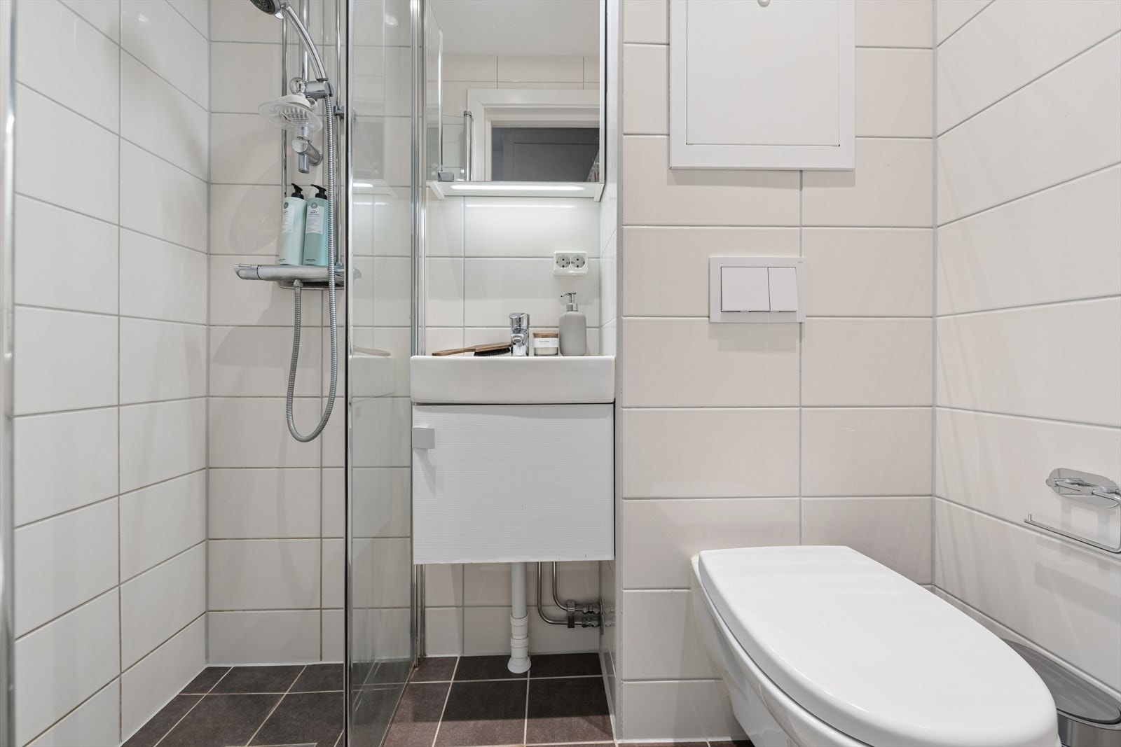 Rommet er utstyrt med vegghengt toalett, servantinnredning og dusjhjørne med glassvegg. Galleribilde