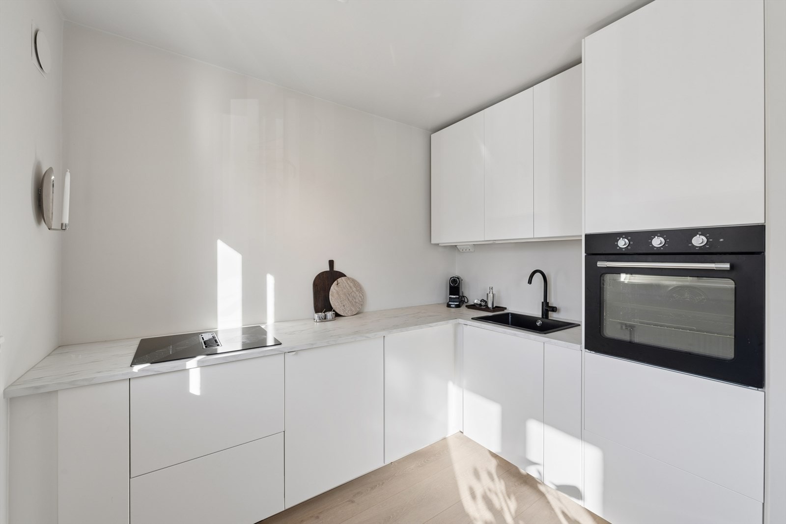 Innredningen har glatte fronter, laminat benkeplate og integrerte hvitevarer. Galleribilde