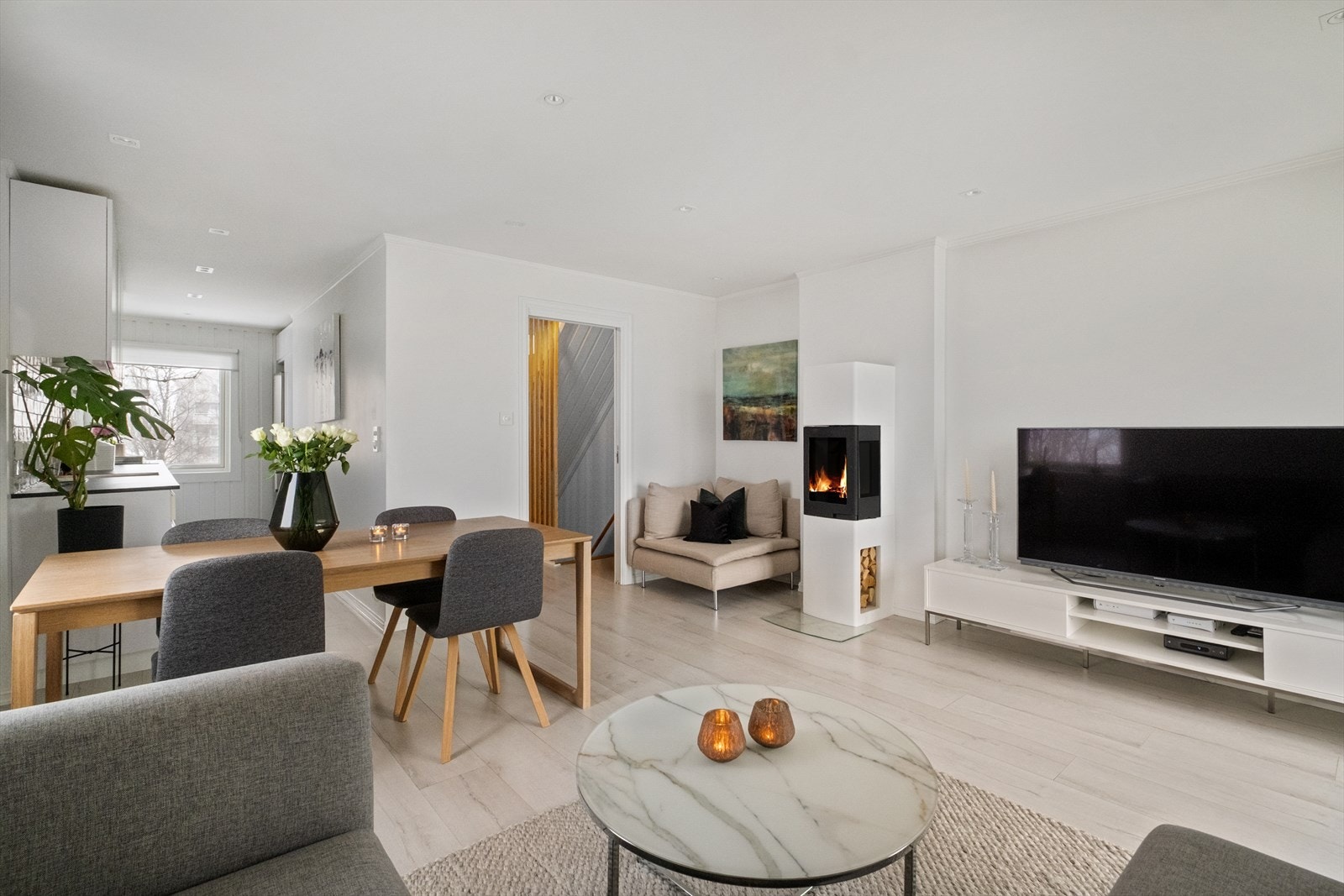 Stuen er romslig og innbydende med store vindusflater som gir rikelig med naturlig lys og en luftig atmosfære Galleribilde