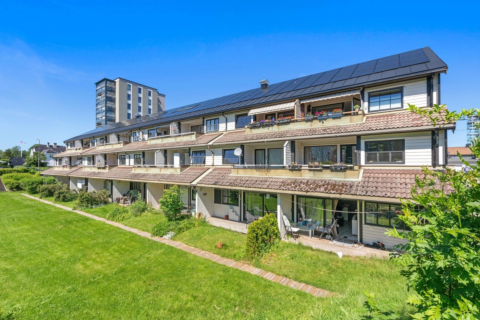 Det er en felles gressplen på fremtiden av leilighetene, som man kan se kommer sola godt inn i leiligheten. Galleribilde