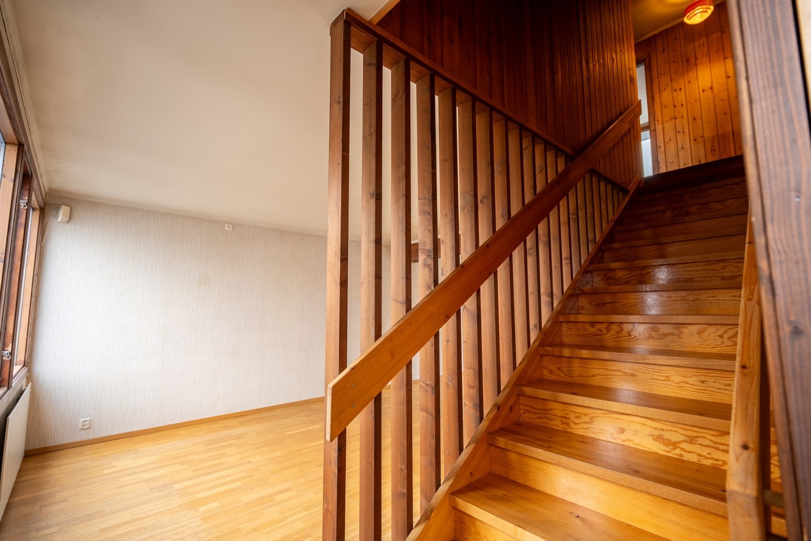 Innvendig trapp i trekonstruksjon som forbinder boligens etasjer. Galleribilde