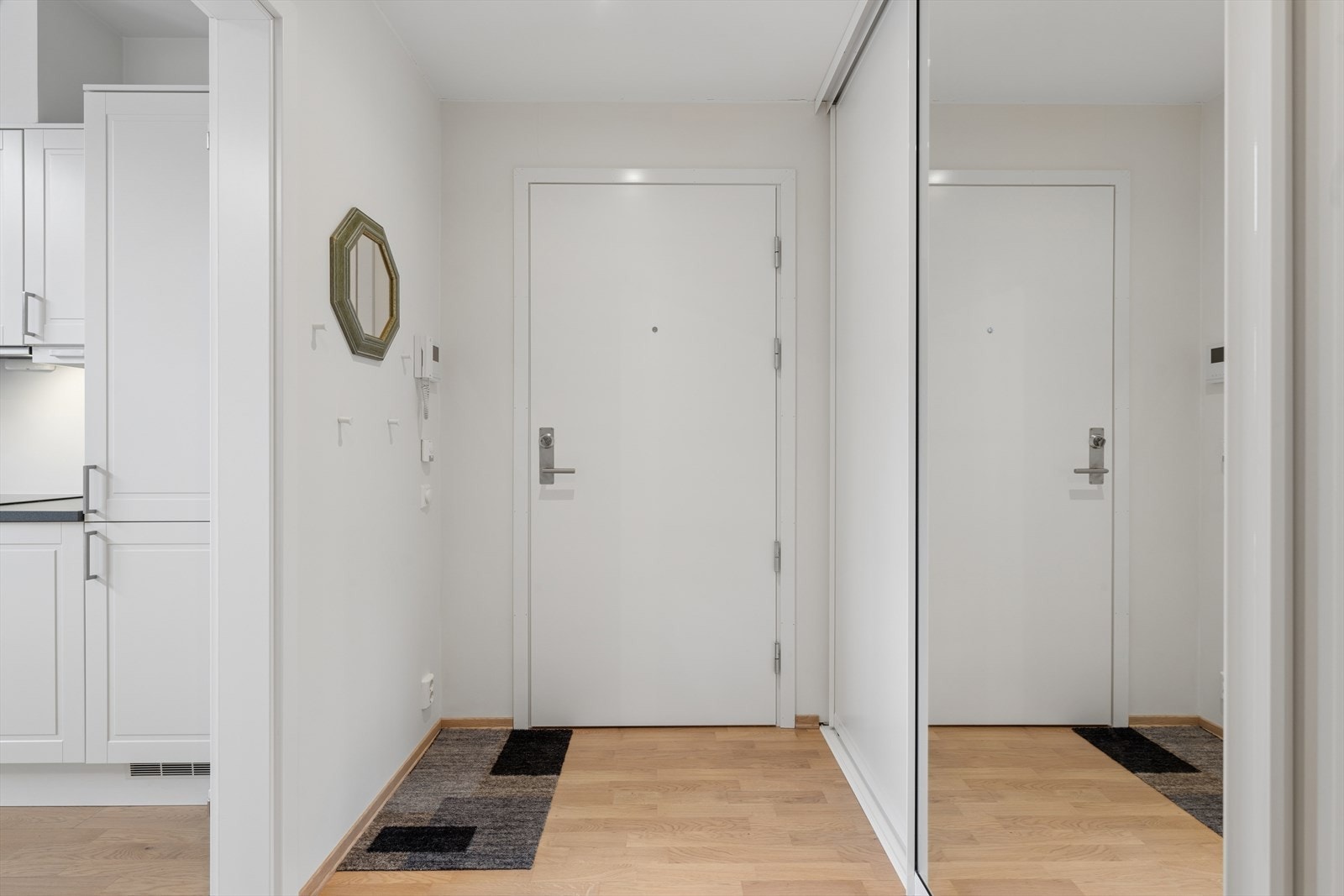 Lys og velkomponert entré med god plass til yttertøy og sko. Det er etablert praktisk garderobeløsning med skyvedører med speil som gir både rikelig lagringsplass og en romslig følelse. Galleribilde