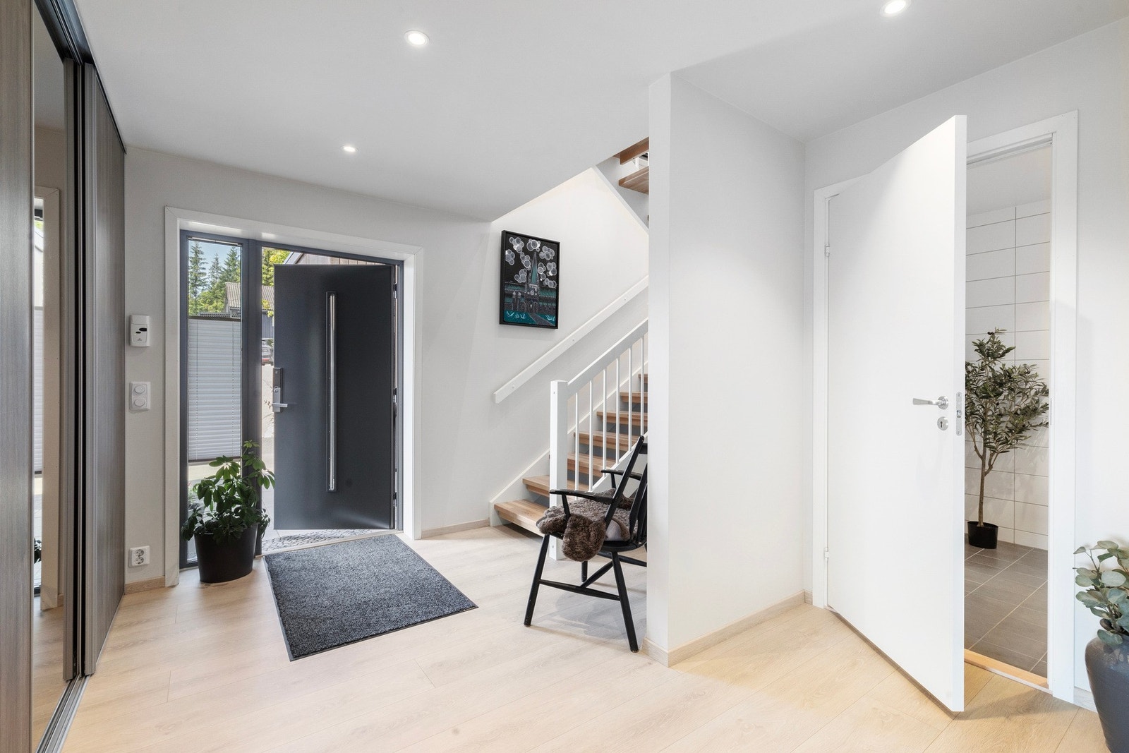 Romslig entré/mellomgang i 1. etasje, innredet med en praktisk skyvedørsgarderobe. Galleribilde