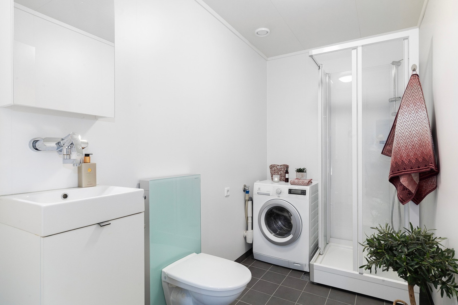 Baderom/vaskerom i 1. etasje med flis på gulv og våtromsplater på vegger og varme i gulv. Galleribilde