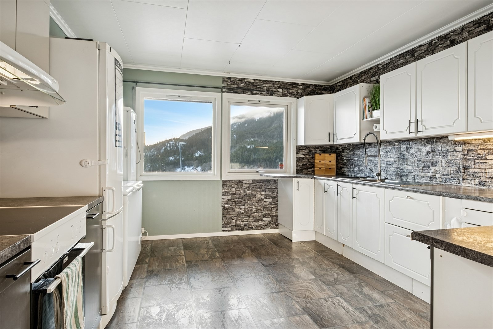 Stort kjøkken hvor man får godt med skap- og benkeplass Galleribilde