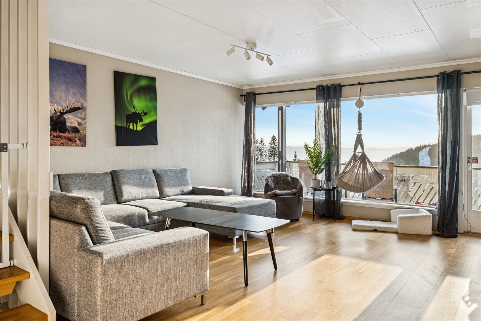 I boligens hovedetasje finner man en romslig stue med store vindusflater som slipper inn rikelig med dagslys og samtidig ivaretar sjøutsikten Galleribilde