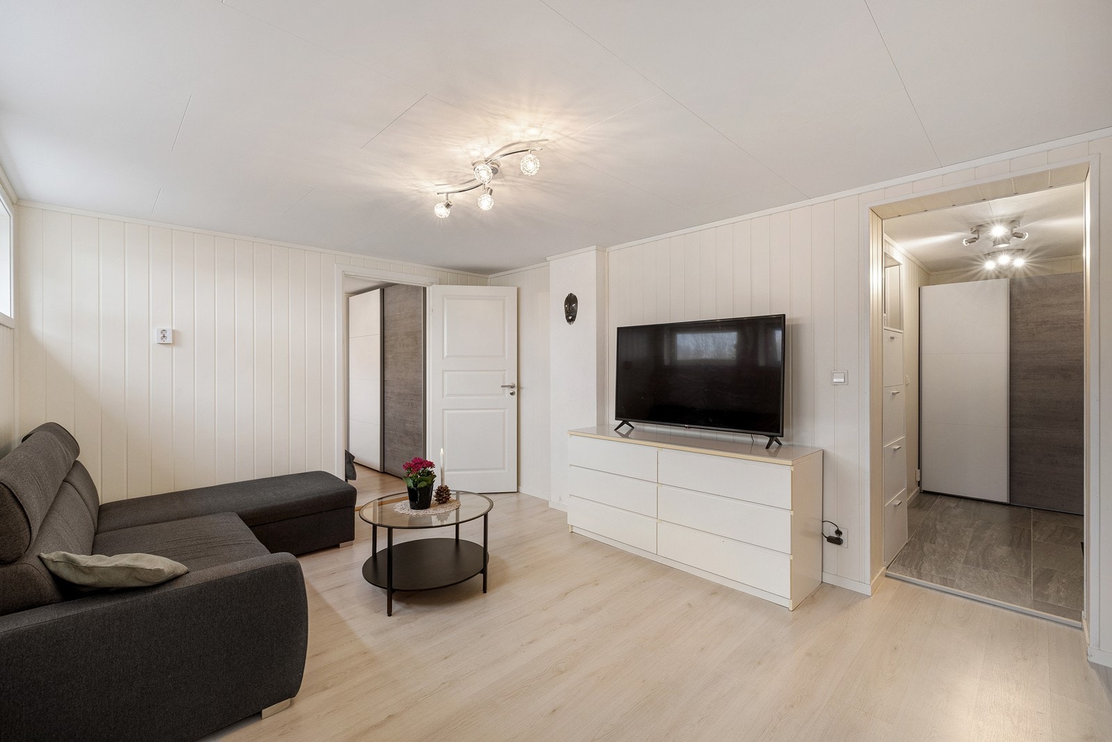 Fra ytterdøren kommer man inn i en gang med skyvedørsgarderobe, med videre inngang til stue og kjøkken. I stuen er det plass til sofa og tv-møbel. Galleribilde