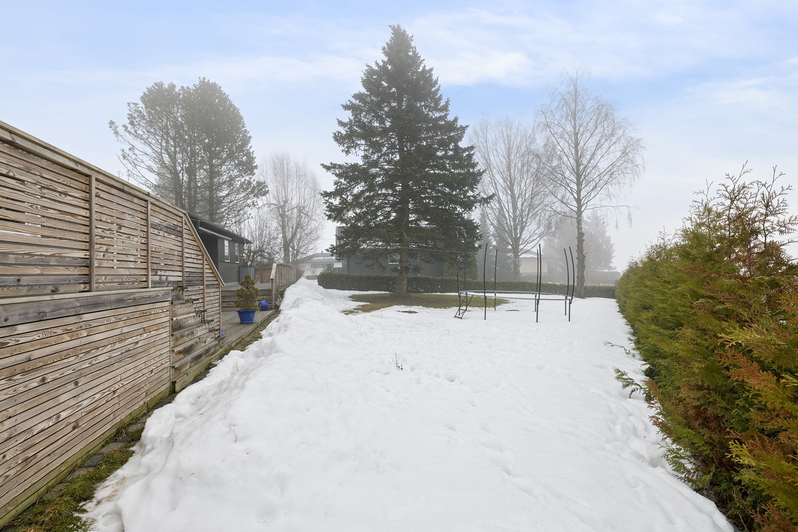 Eiendommen har en flat tomt, pent opparbeidet med gressplen, hekk og øvrig beplantning Galleribilde