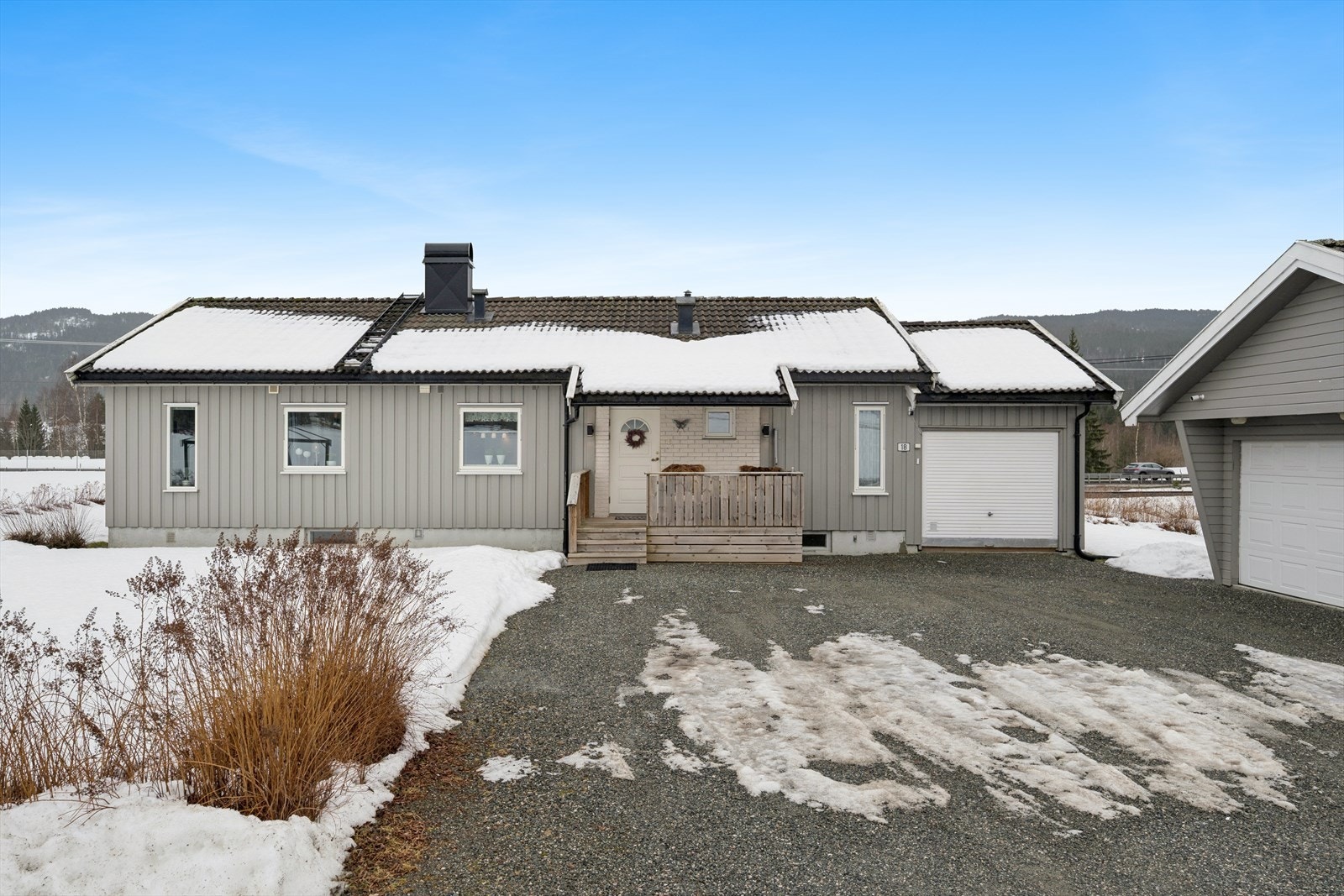 Enebolig med tilknyttet garasje og en stor, frittstående garasjebygning. Galleribilde